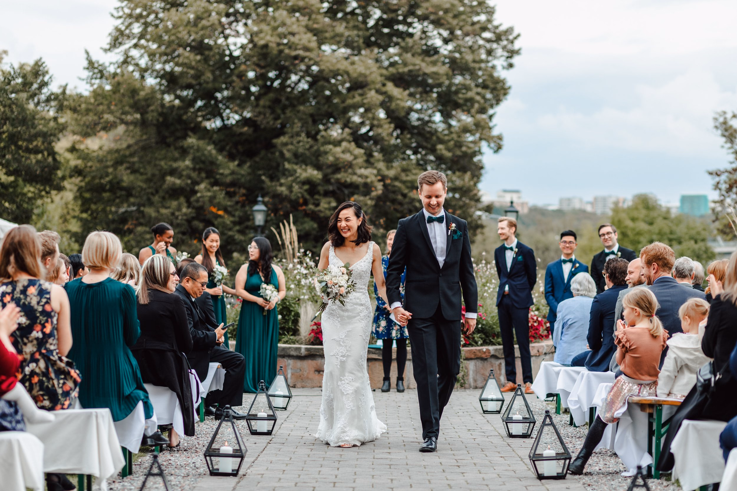 Newlyweds walking through seated guests after an outdoor ceremony