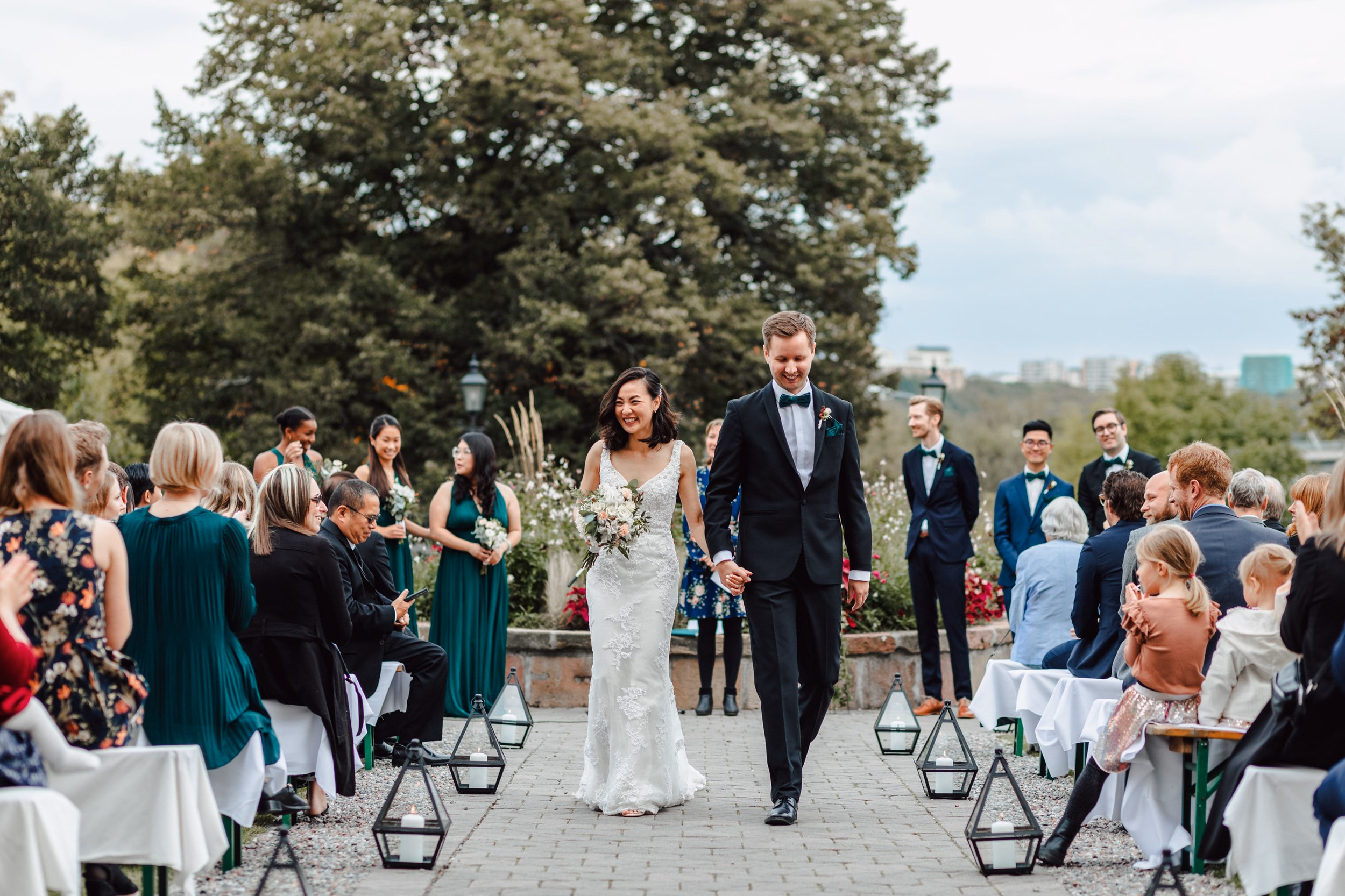 A newly married couple leaving their ceremony through cheering guests