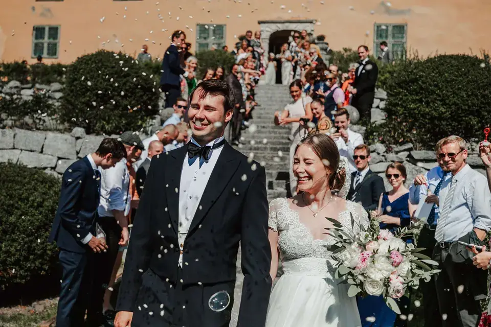 Wedding guests celebrating the couple with confetti.
