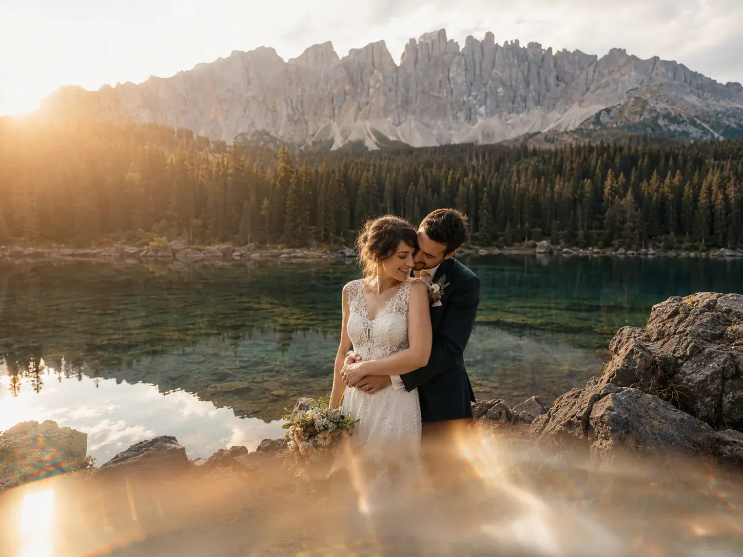 Conceptual editorial scene of a wedding couple beside a mountain lake at sunset