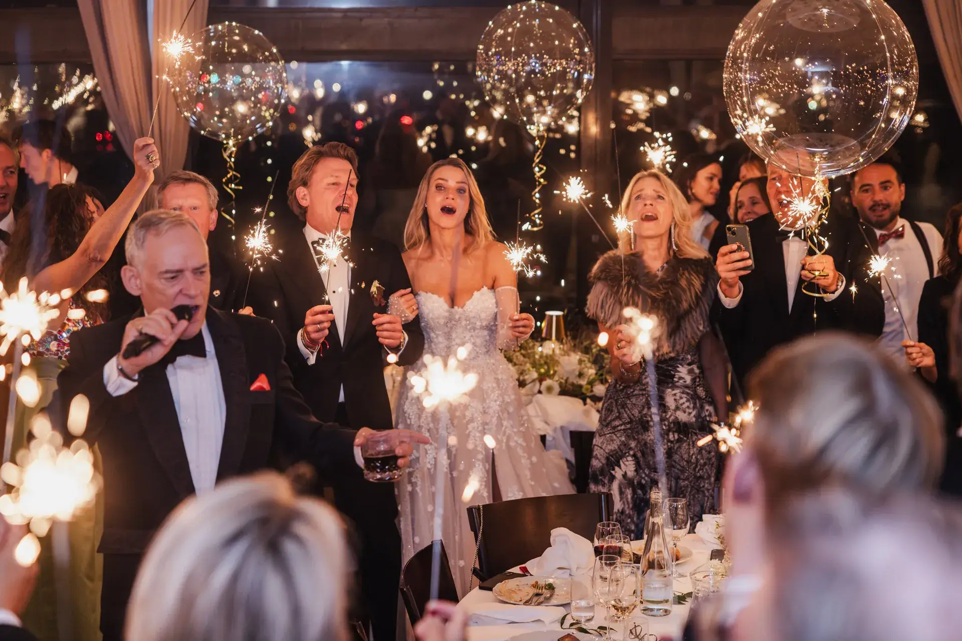 A bride and wedding guests celebrating with sparklers during the reception.