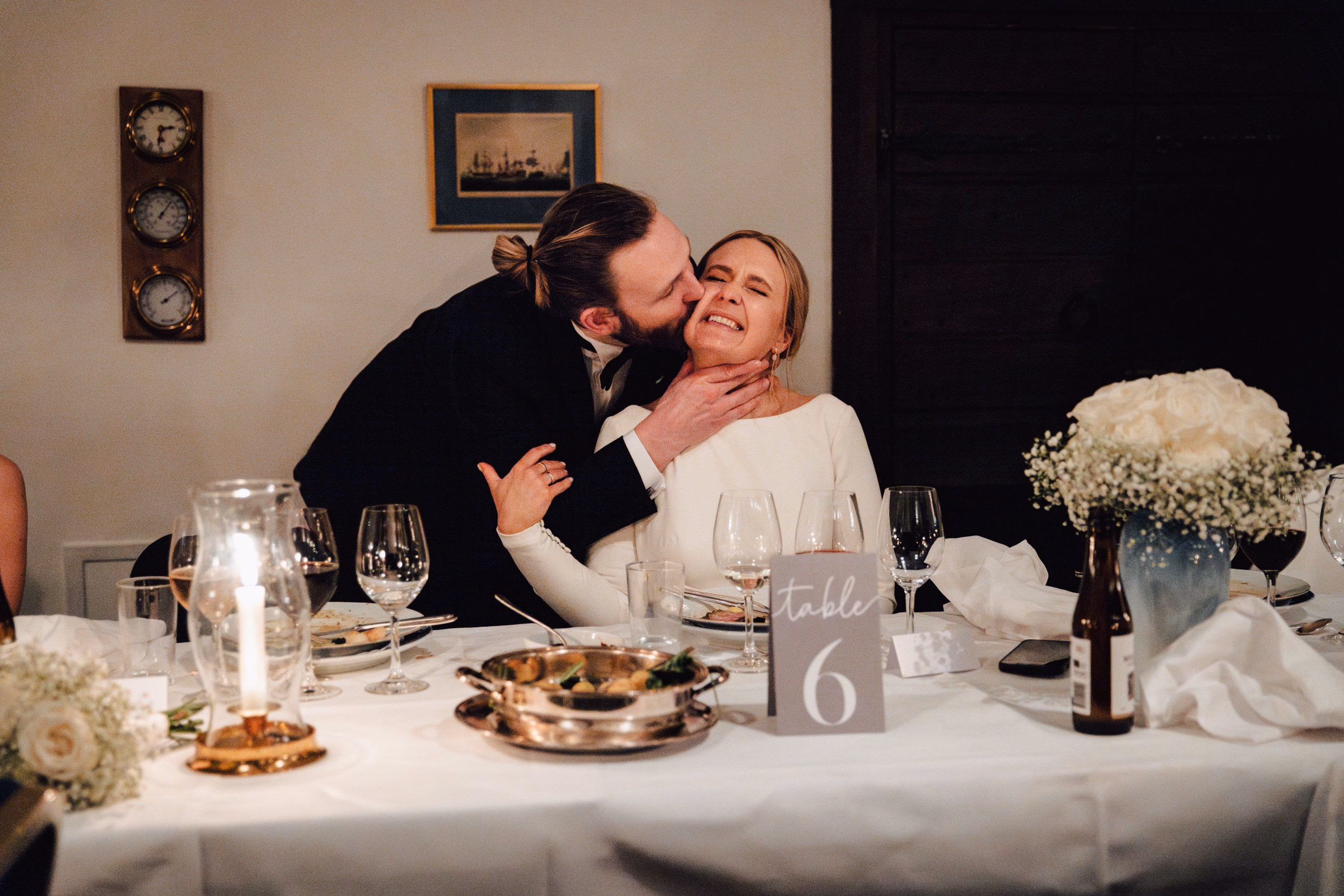 Groom kissing the bride during the wedding dinner