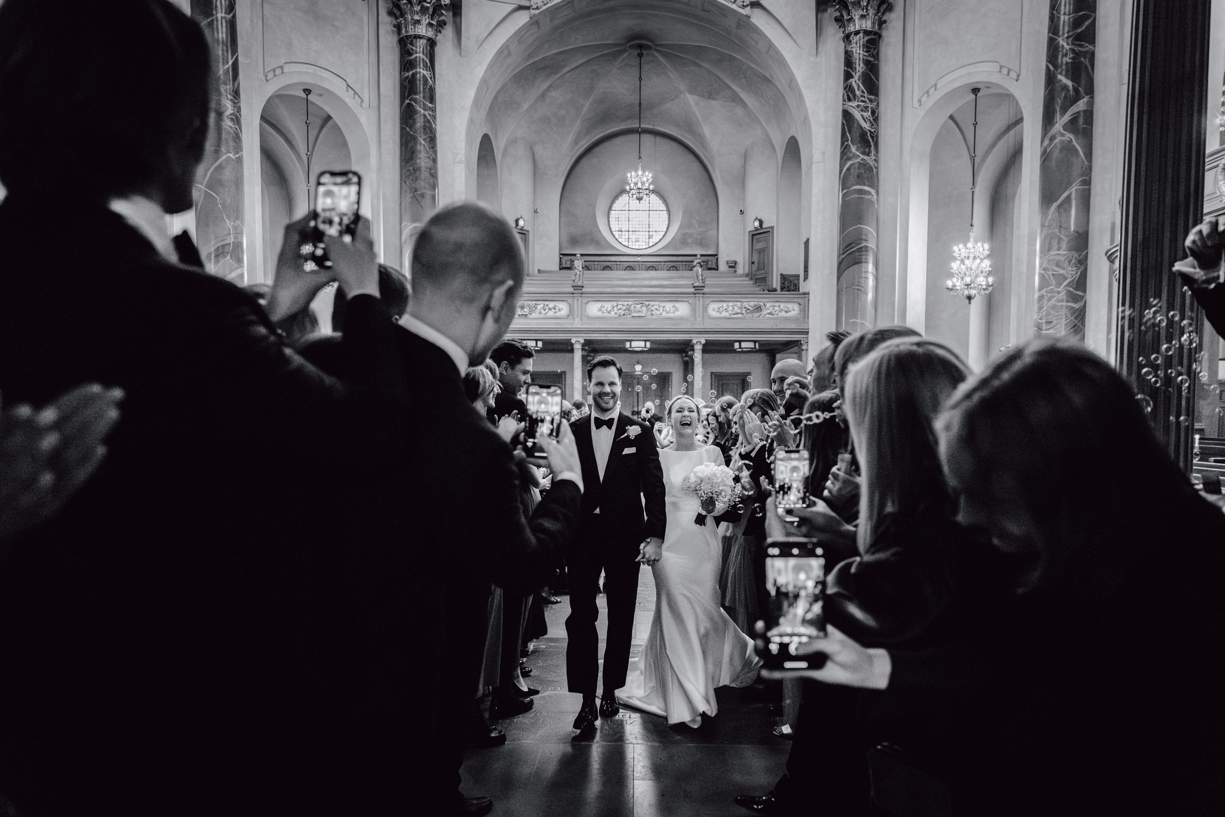 Church wedding ceremony seen from behind the guests in black and white