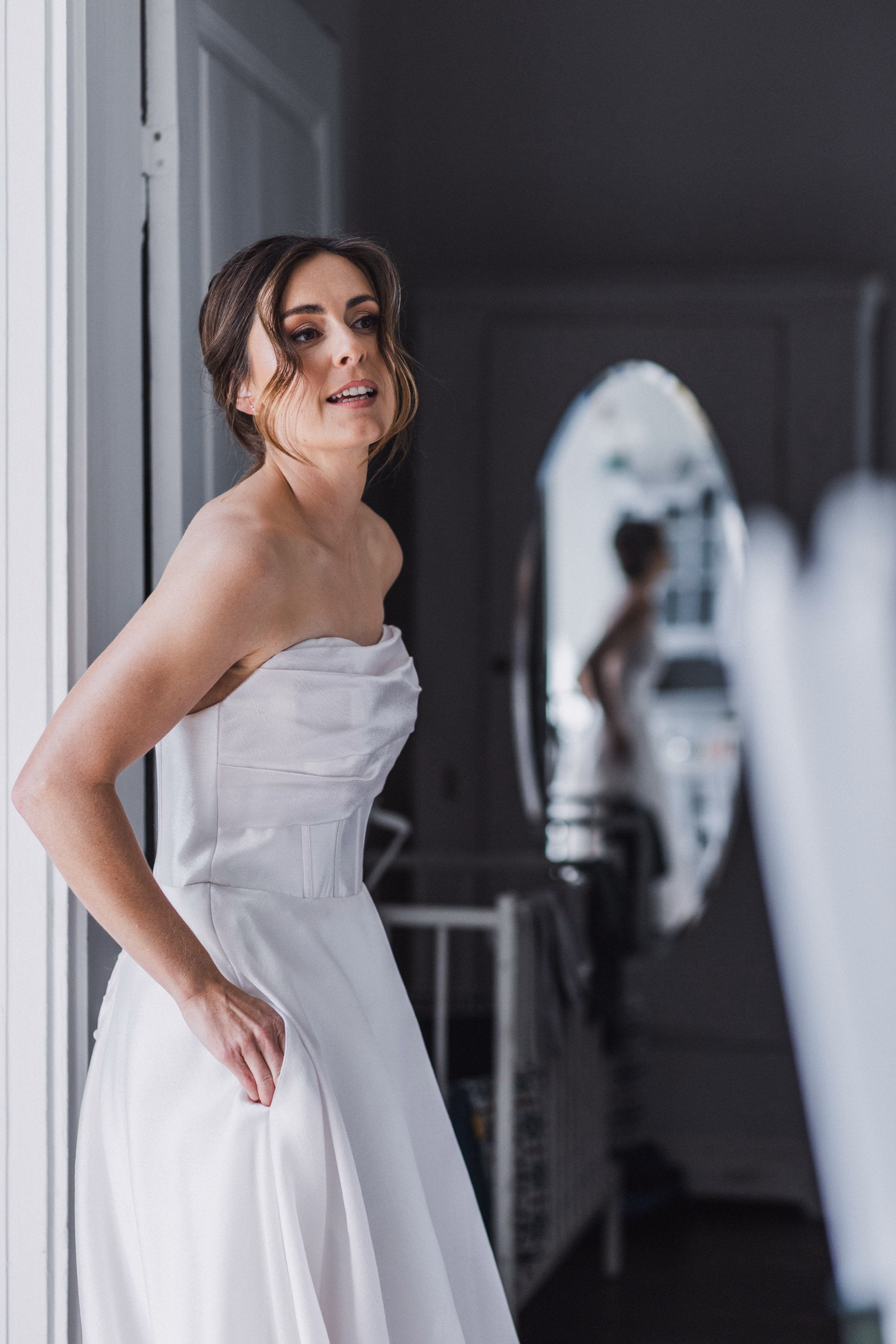 Bride standing beside a window before the ceremony