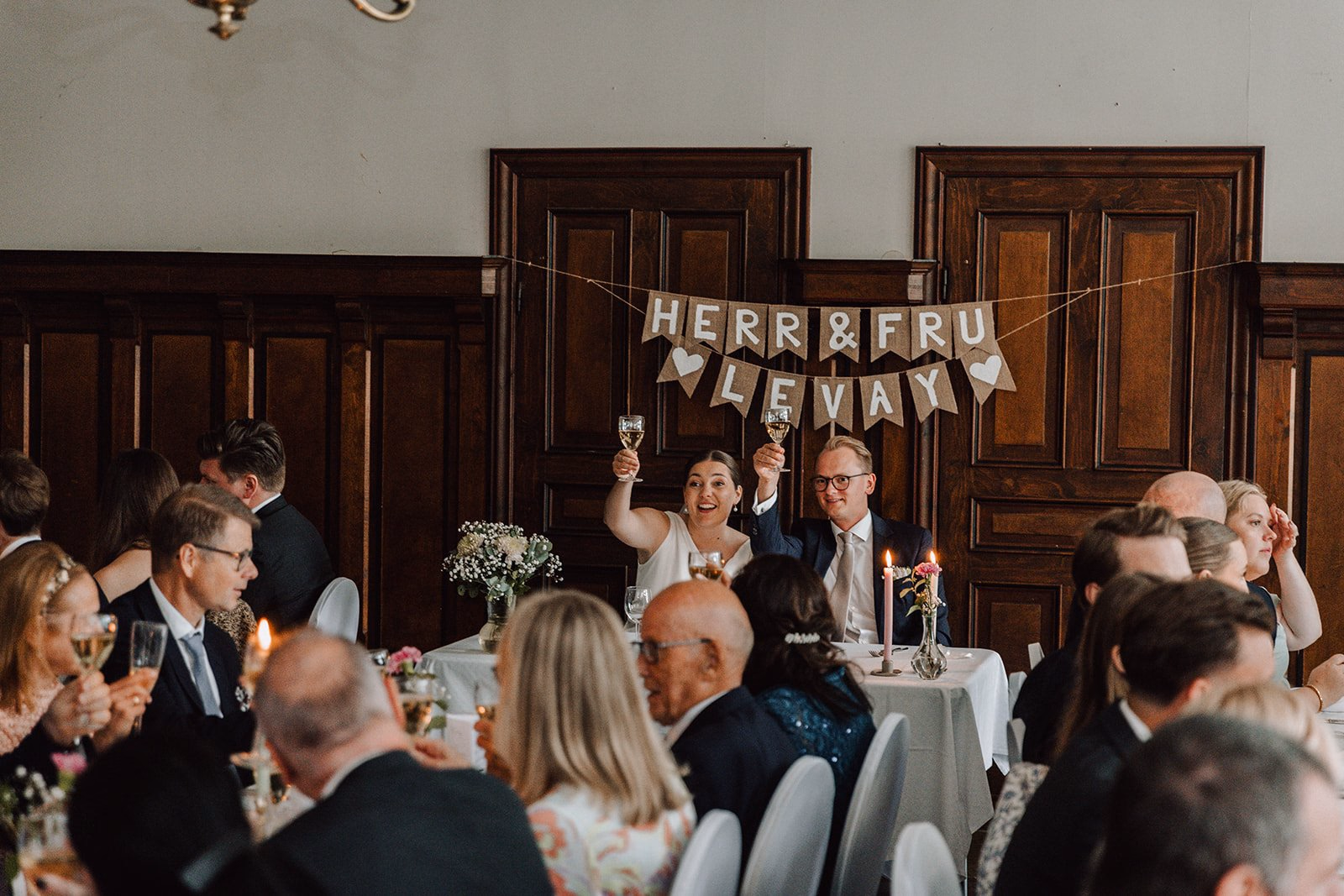 Wedding guests raising a congratulatory sign during the reception