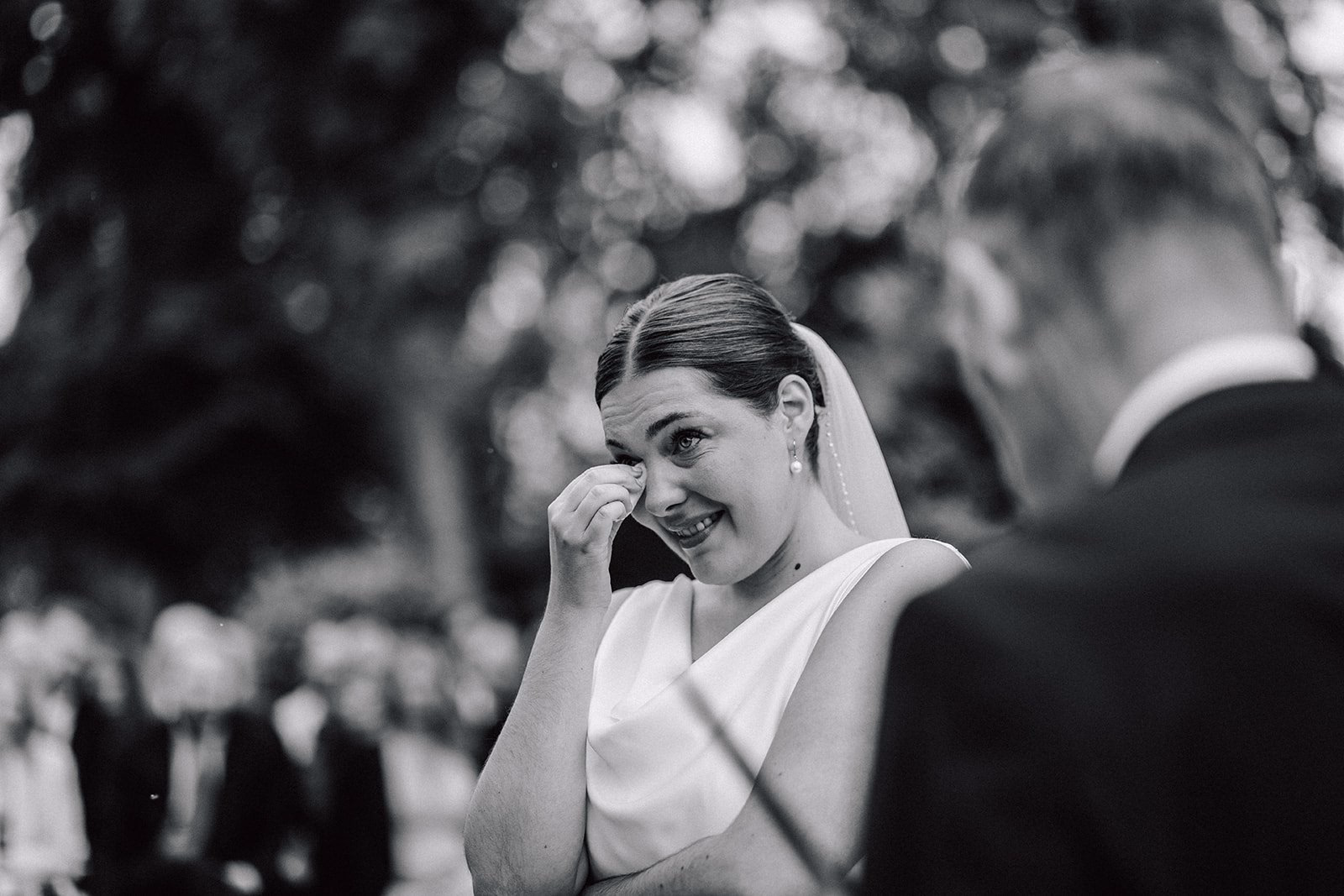 Bride smiling at her partner in a black-and-white portrait