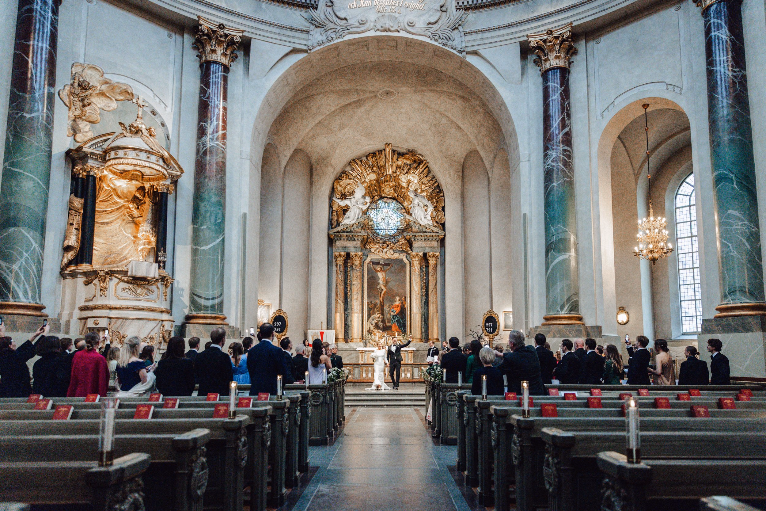 Wide view of guests seated inside a church wedding ceremony
