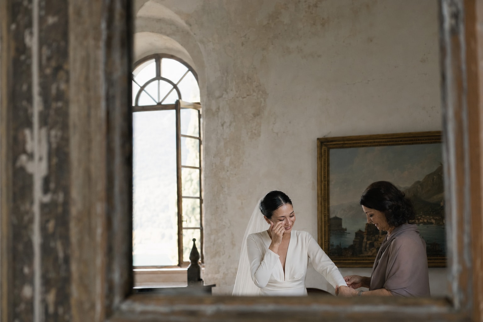 Bride getting ready at Villa San Vigilio on Lake Garda, Italy, sharing an emotional moment before her wedding ceremony.