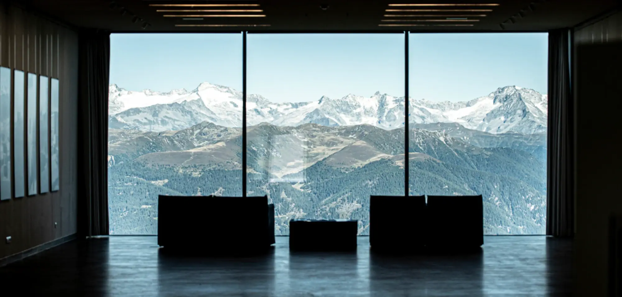 Mountain panorama seen through floor-to-ceiling windows.