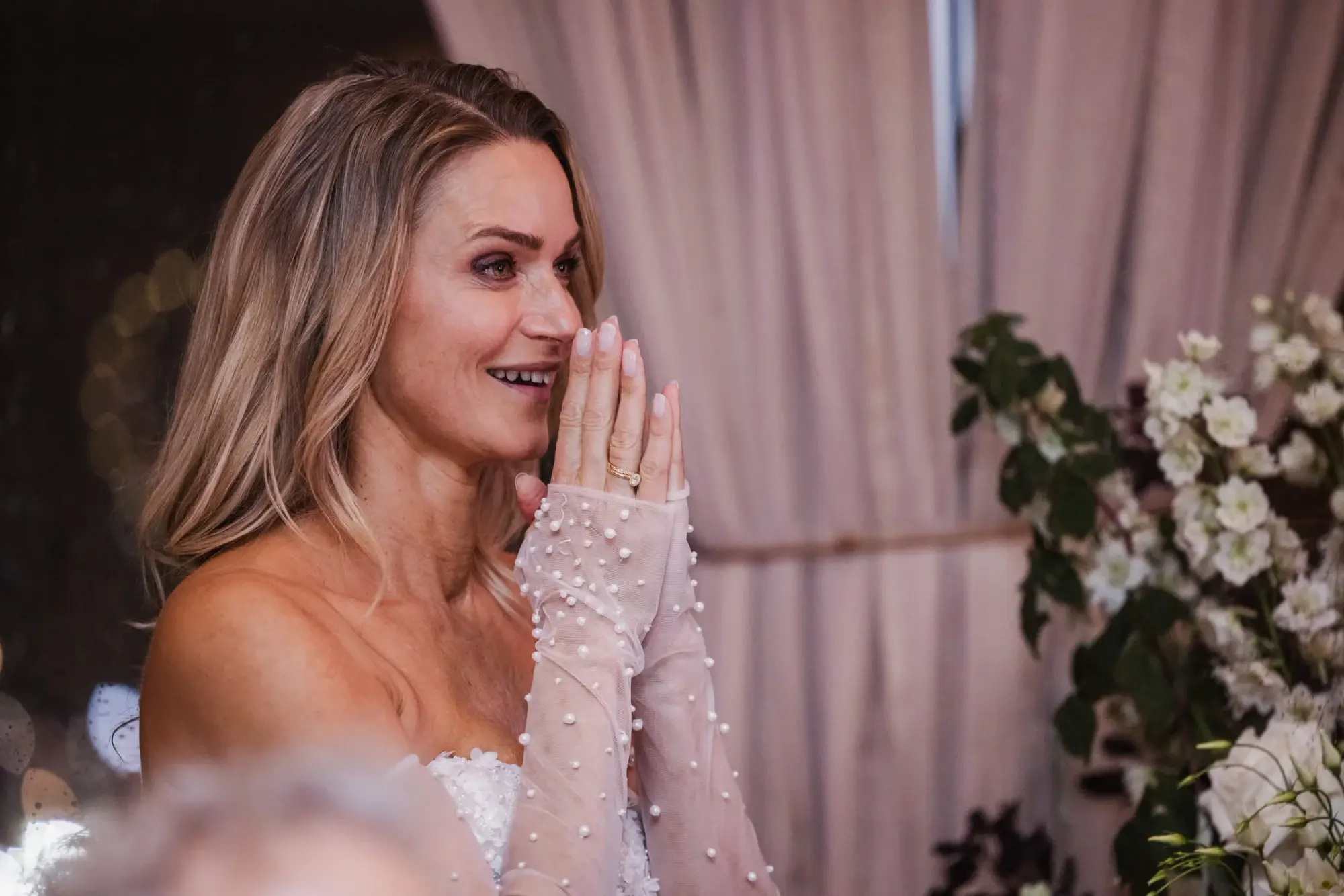 Bride reacting with joy to a surprise live performance during the wedding dinner