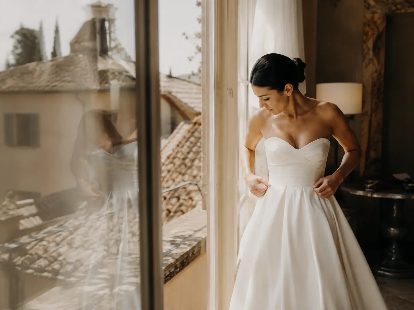 Bride getting ready inside Borgo Stomennano with soft natural light and views over the Tuscan countryside before the wedding ceremony.