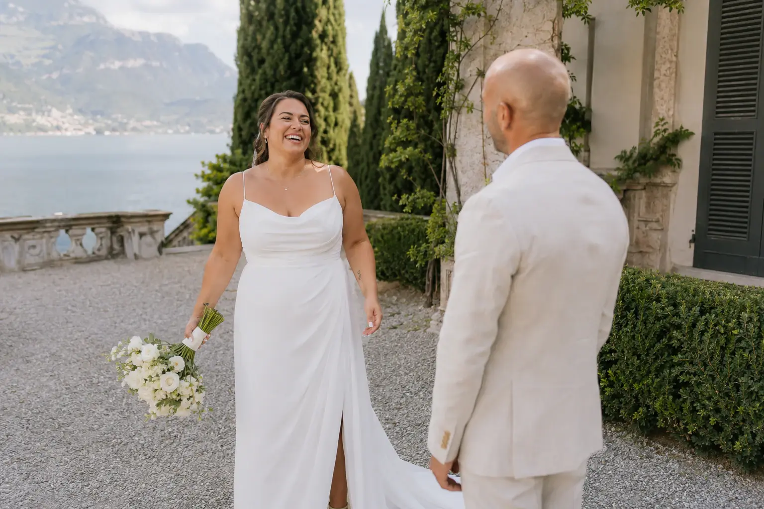 Couple meeting in a lakeside villa garden.