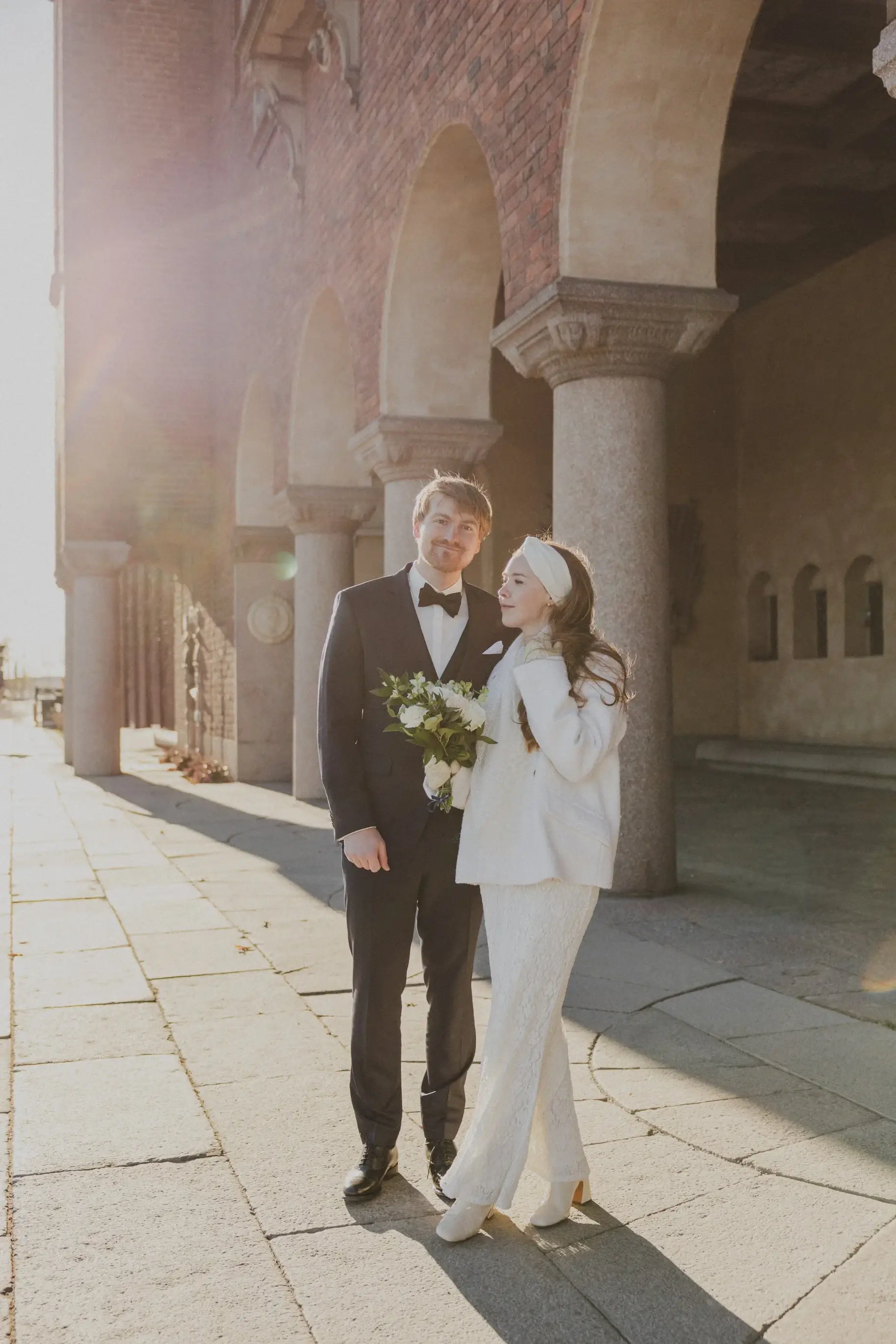 Couple walking through an arcade at Stockholm City Hall.