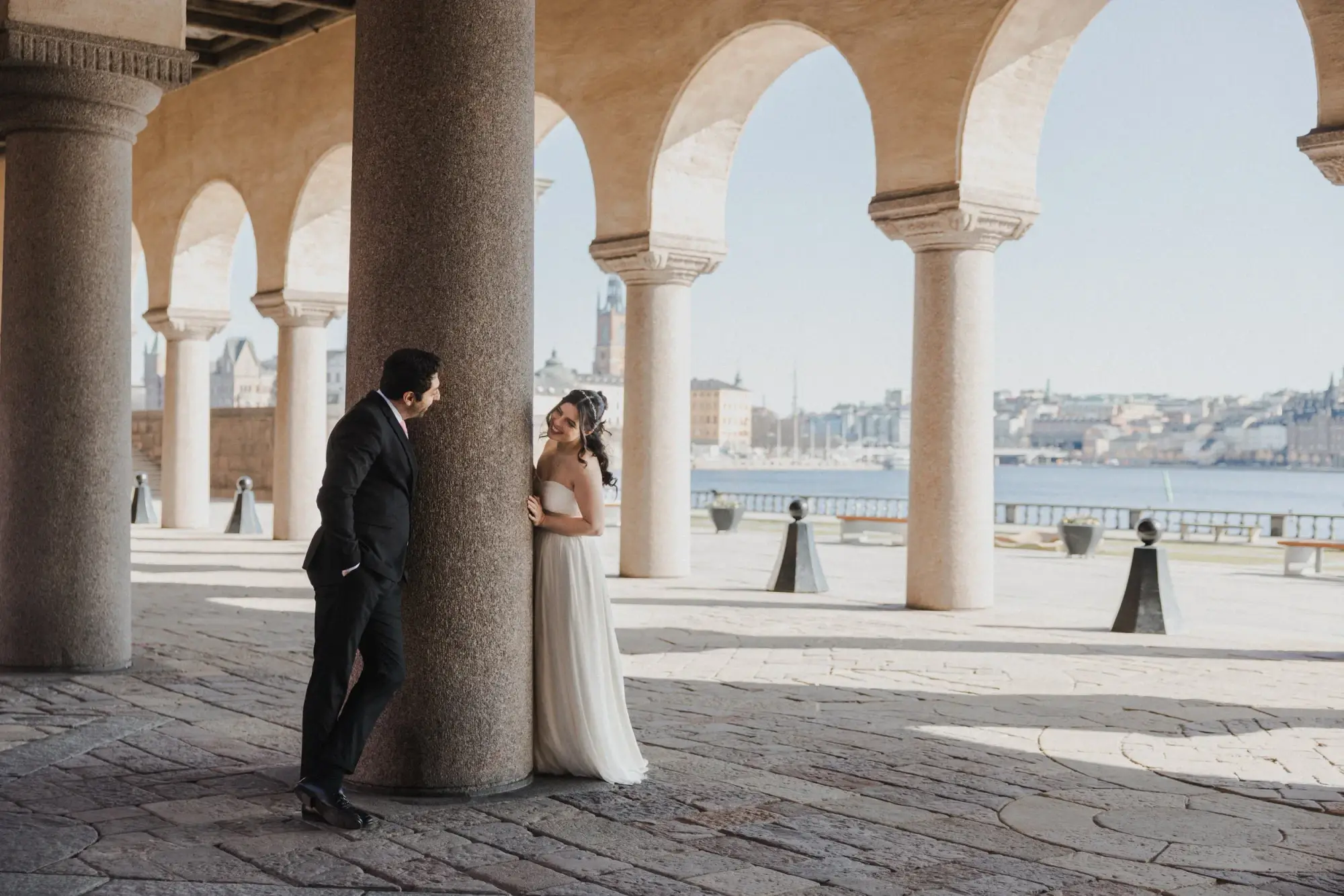 Couple sharing a quiet moment beside a column at Stockholm City Hall.