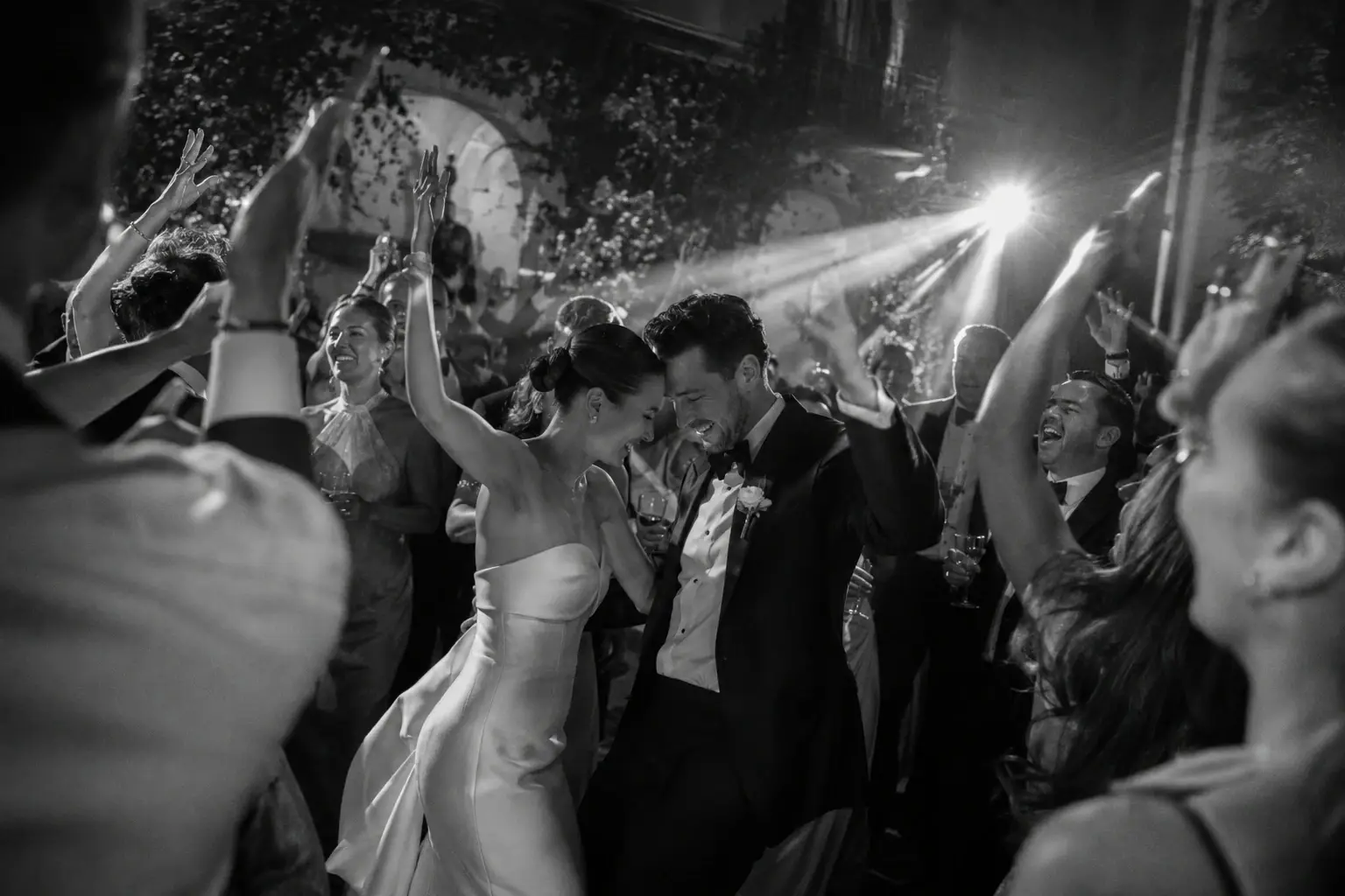 Documentary wedding photography capturing the bride and groom dancing with guests during an Italy destination wedding reception.