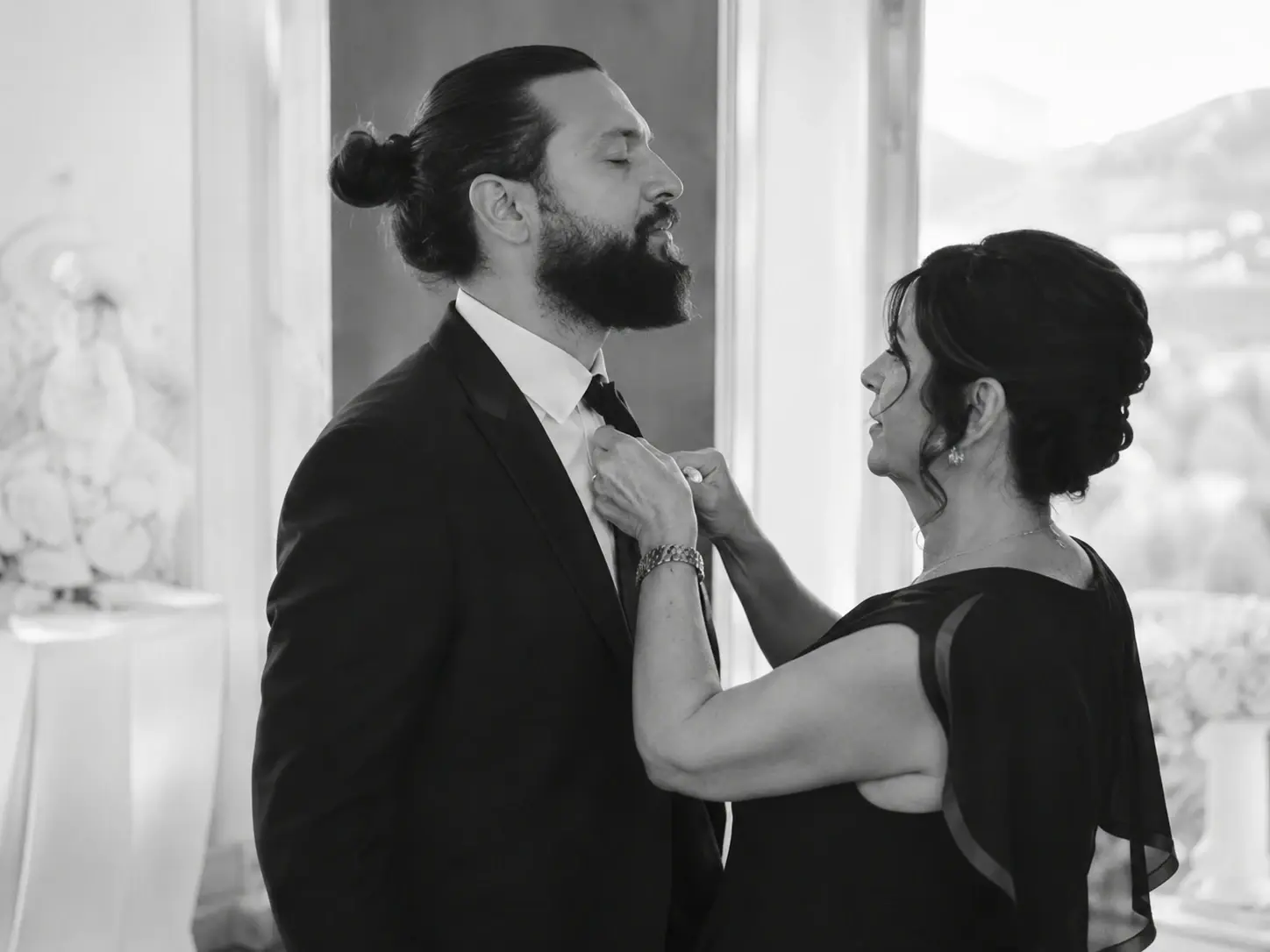 Black and white getting ready moment at Grand Hotel Tremezzo with groom adjusting his tie before the Lake Como wedding ceremony.