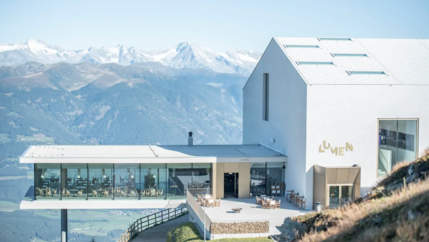 Modern mountain venue surrounded by snowy peaks.