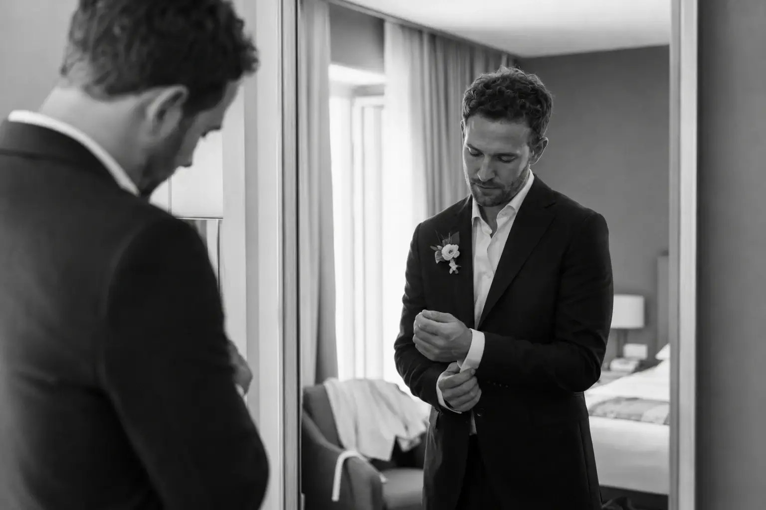 Groom adjusting his cufflinks while getting ready in Riva del Garda before his destination wedding on Lake Garda.