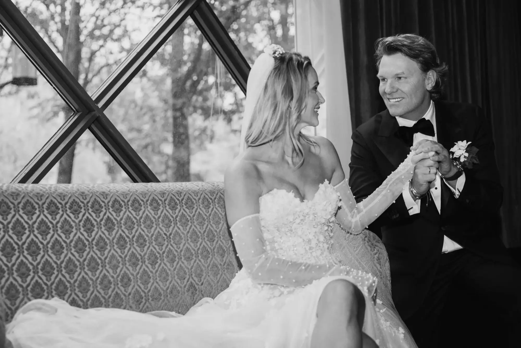 Couple holding hands during a relaxed black-and-white wedding portrait at Café Opera