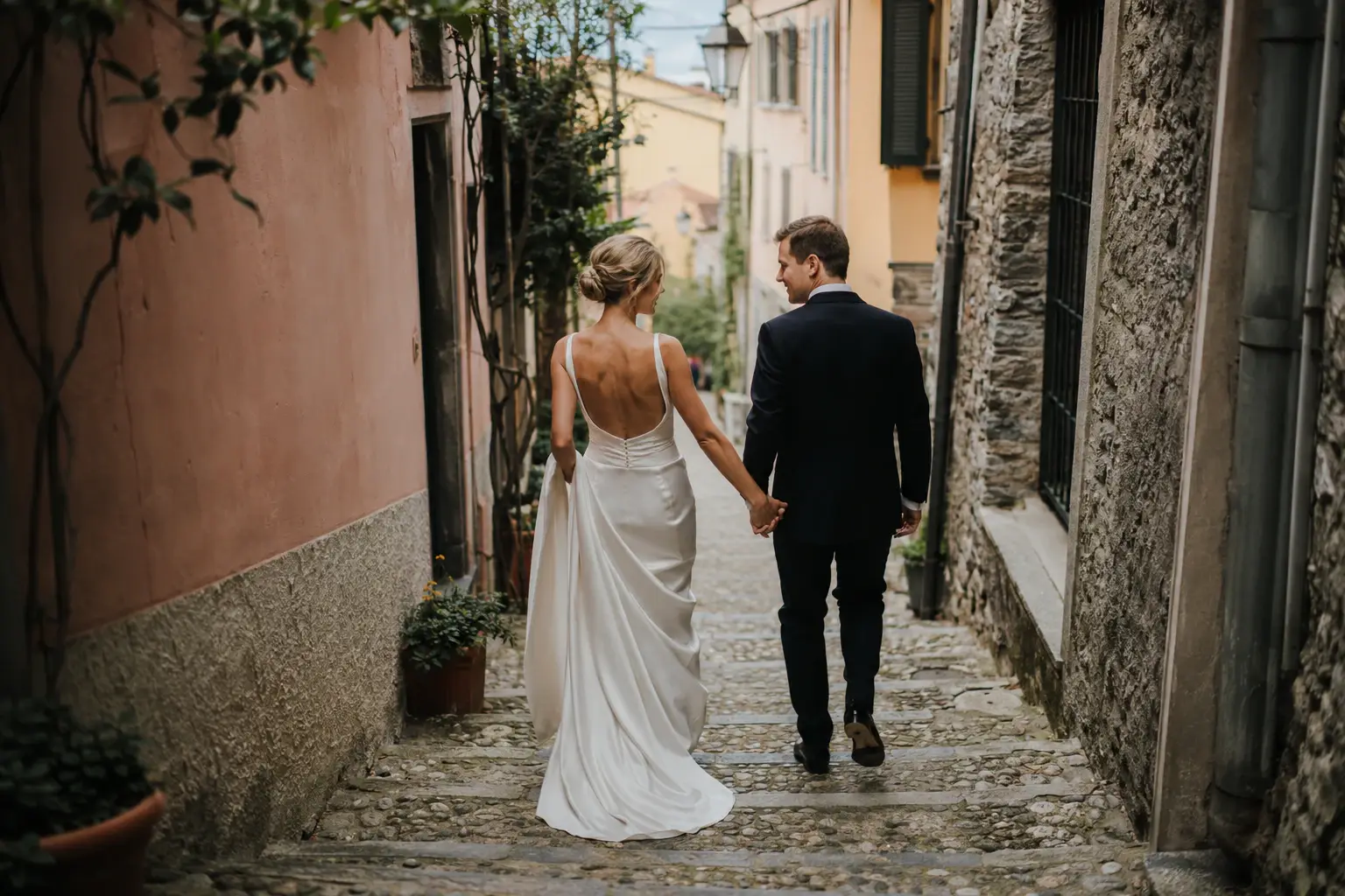 Bride and groom walking through the old stone streets of Bellagio, romantic Lake Como wedding photography in Northern Italy
