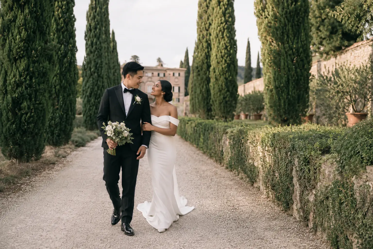 Bride and groom walking through the iconic cypress-lined avenue at Villa Cetinale during their destination wedding in Tuscany.