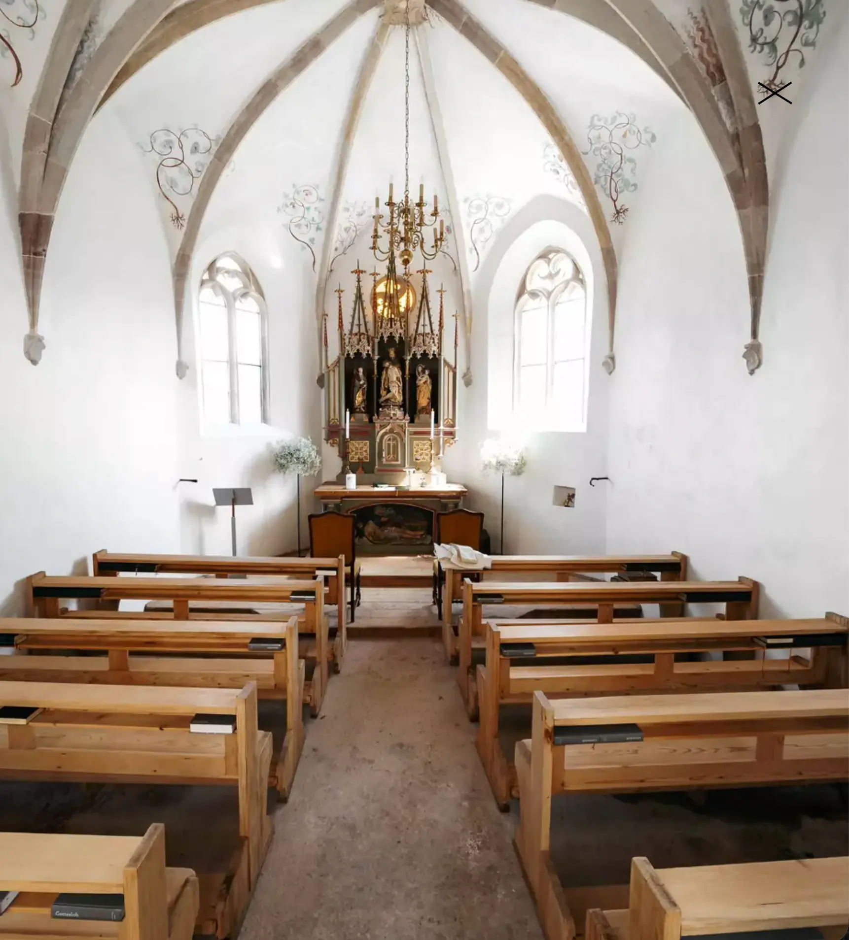Interior of a small chapel with wooden pews.