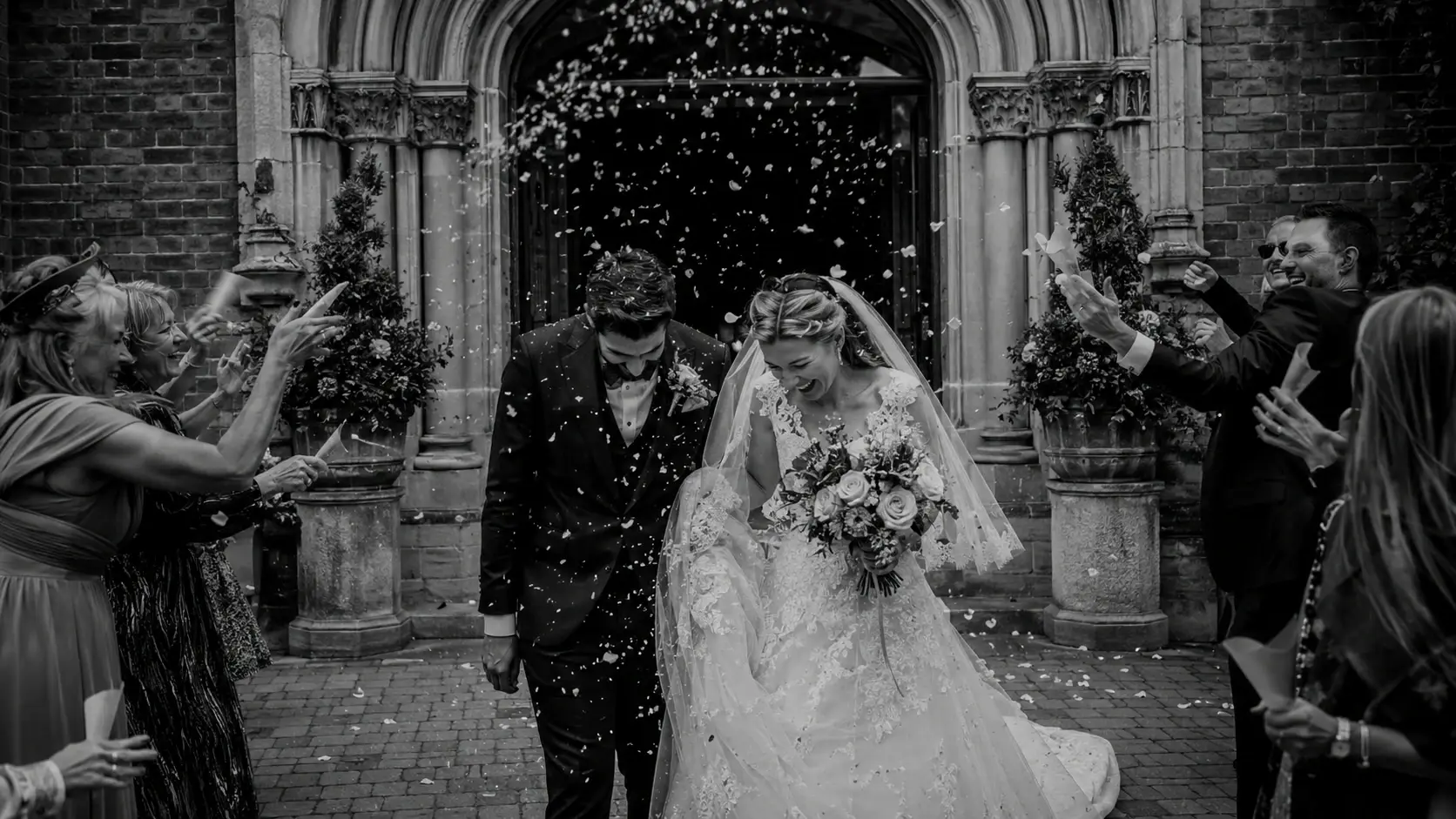 Bride and groom exiting an Italian church surrounded by confetti after their destination wedding ceremony in Italy.
