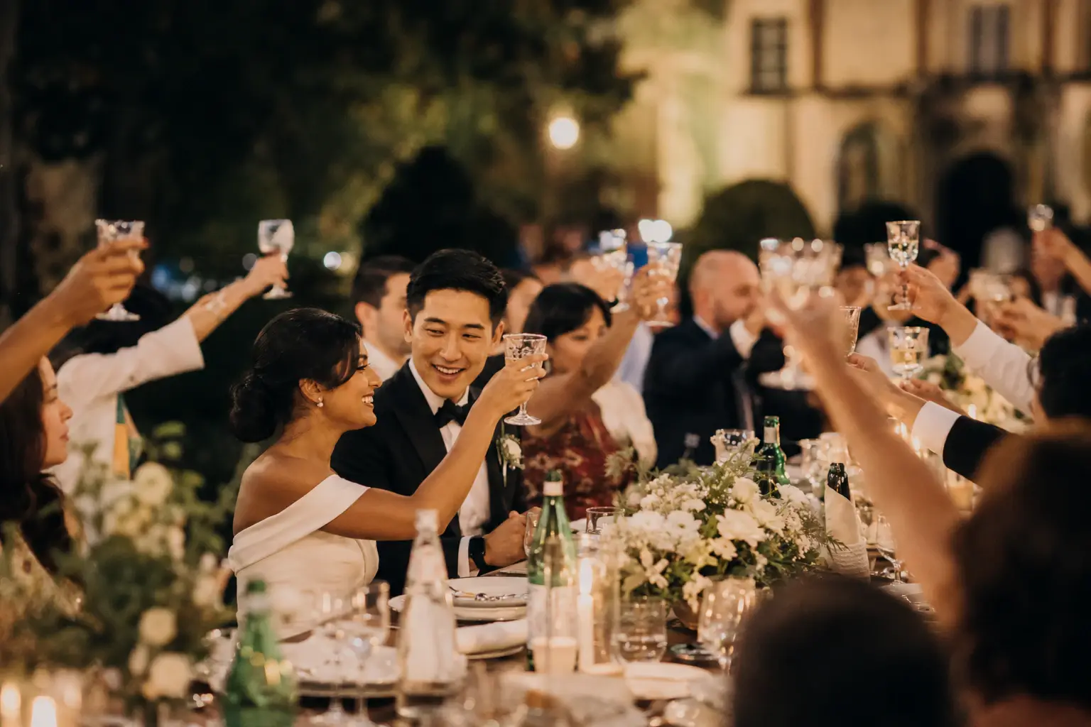 Bride and groom toasting with guests during the wedding dinner at Villa Cetinale in Tuscany, Italy.