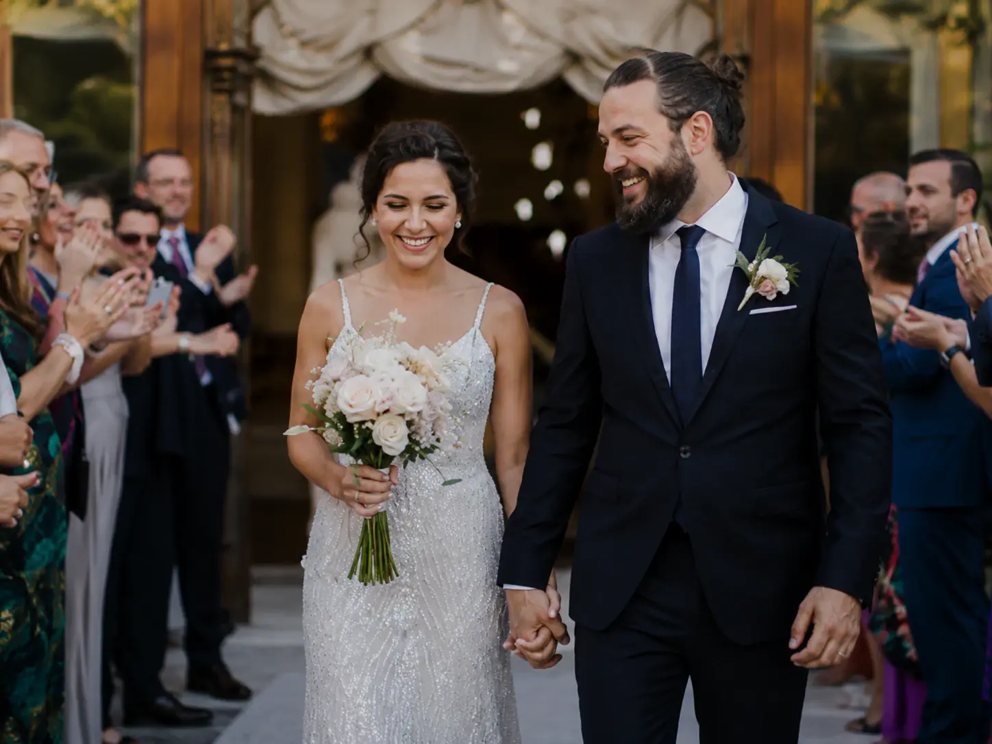 Newlyweds leaving their ceremony through cheering guests.