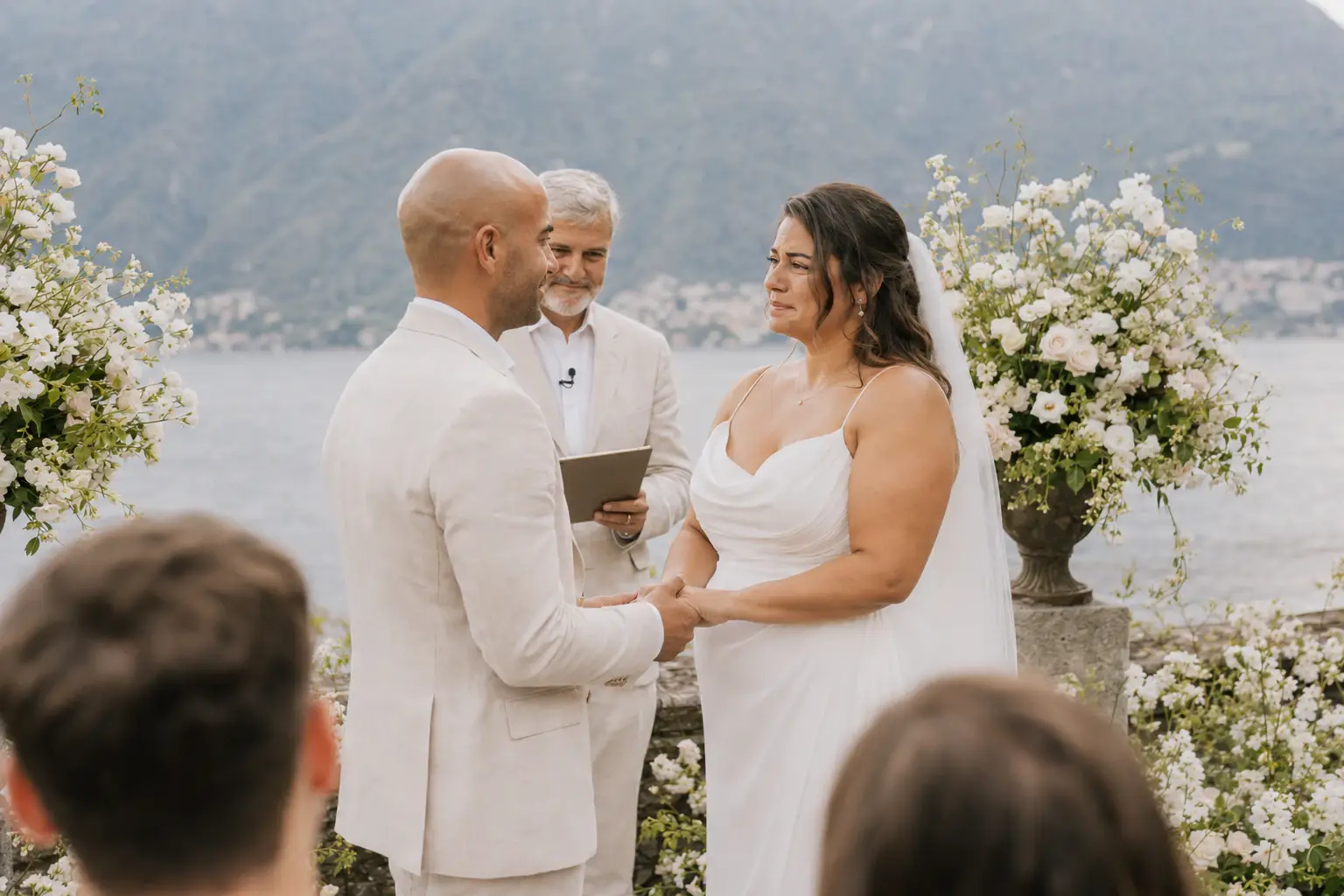 Couple exchanging vows during a lakeside ceremony.