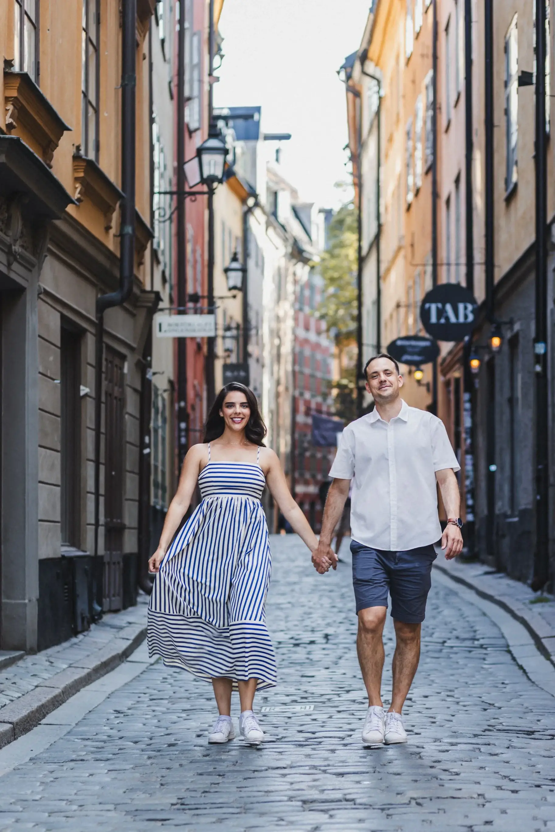 Couple holding hands while walking through a Stockholm street.