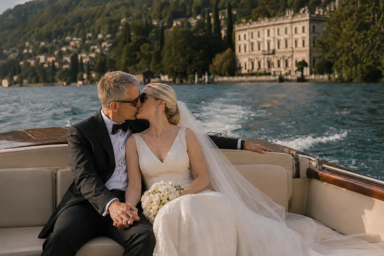 Newlyweds kissing on a wooden boat on Lake Como.