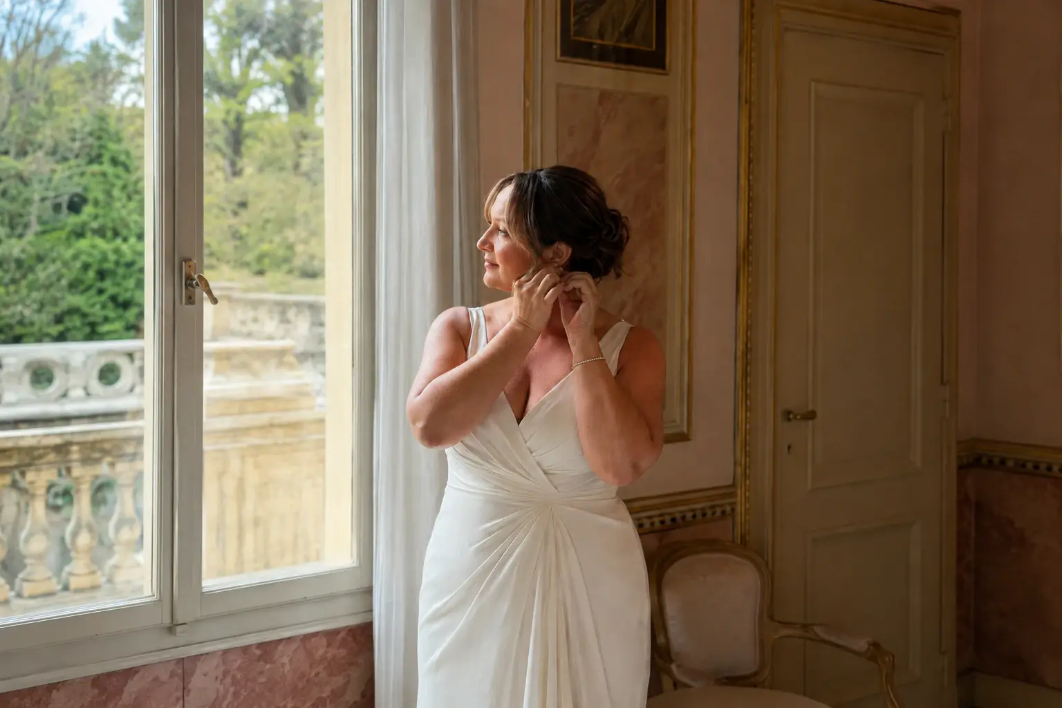 Bride getting ready near the window inside Villa Pizzo with soft natural light and lake views in the background.