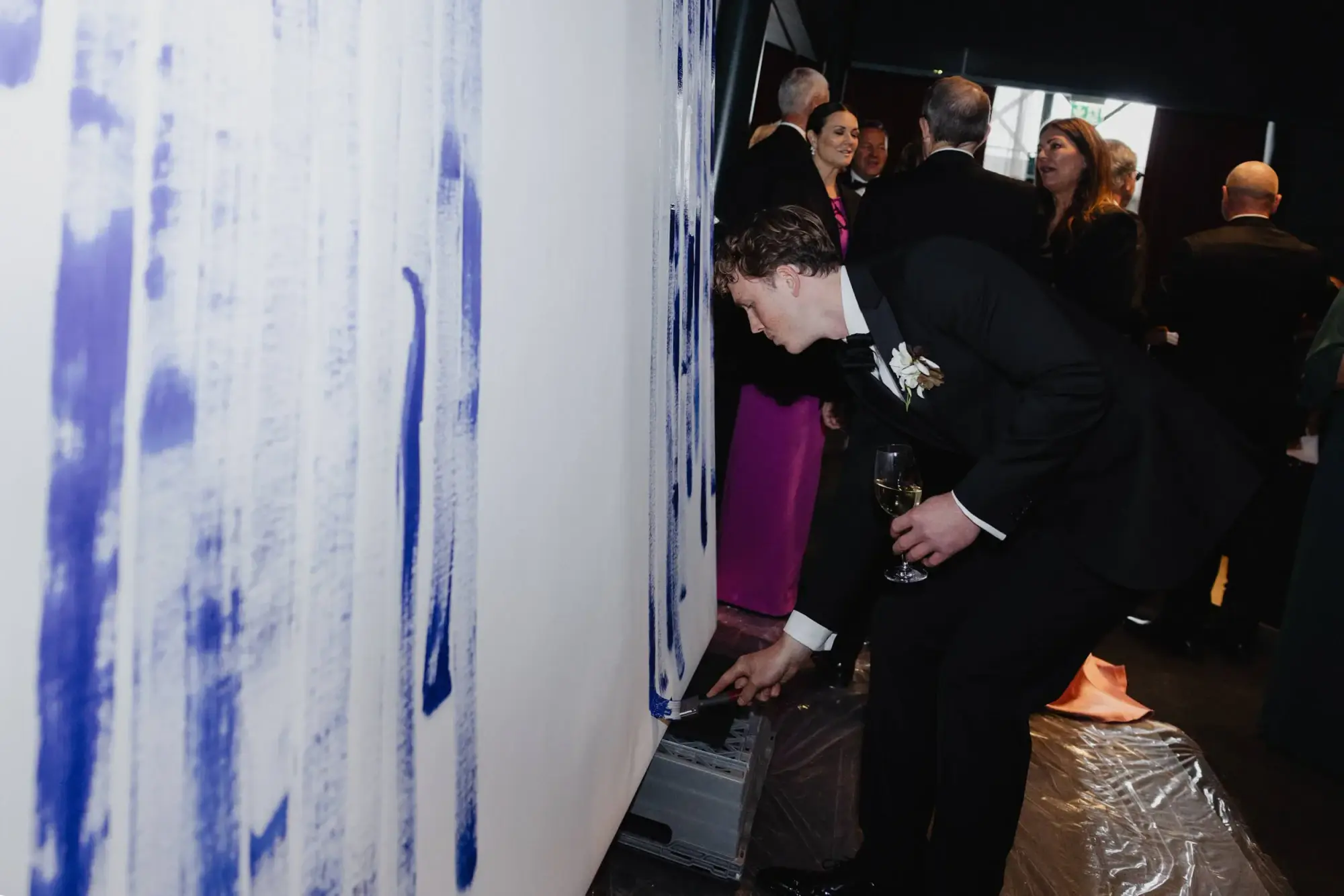Wedding guest adding a blue brushstroke to Jeppe Hein’s collaborative artwork at Café Opera