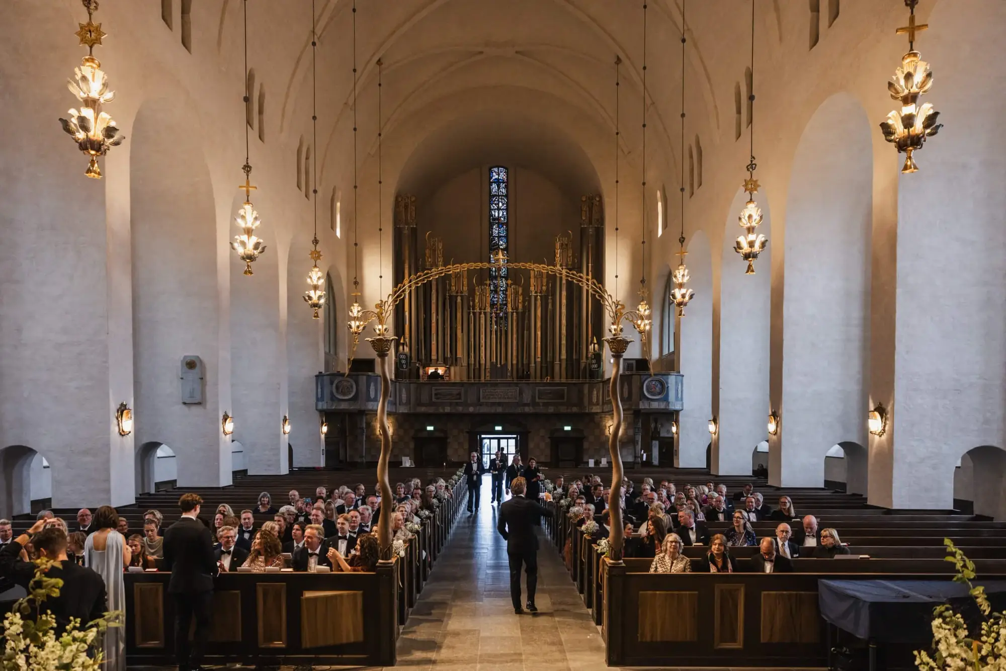 Grand interior of Högalidskyrkan filled with guests before the wedding ceremony