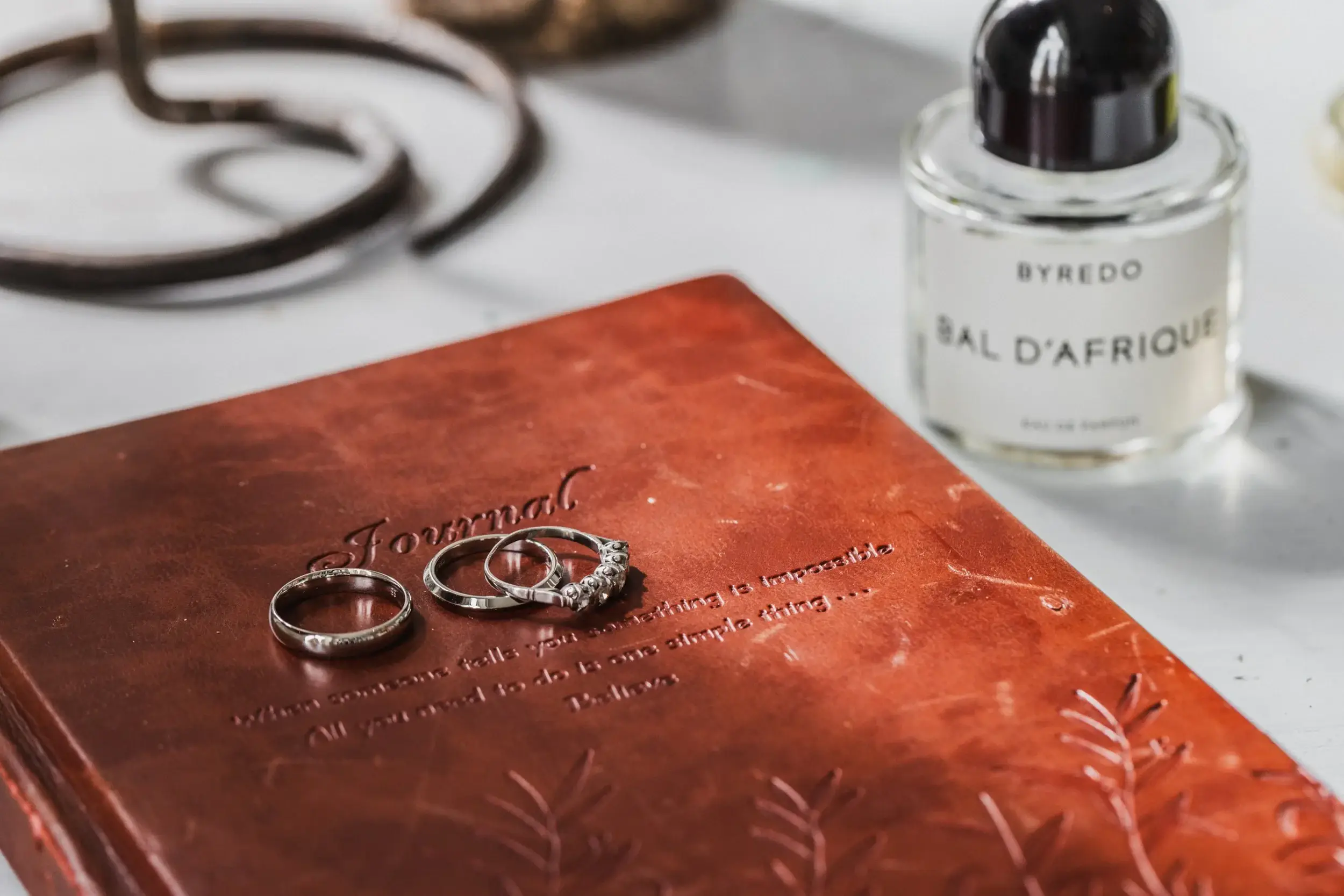 Wedding rings resting on a red invitation card.