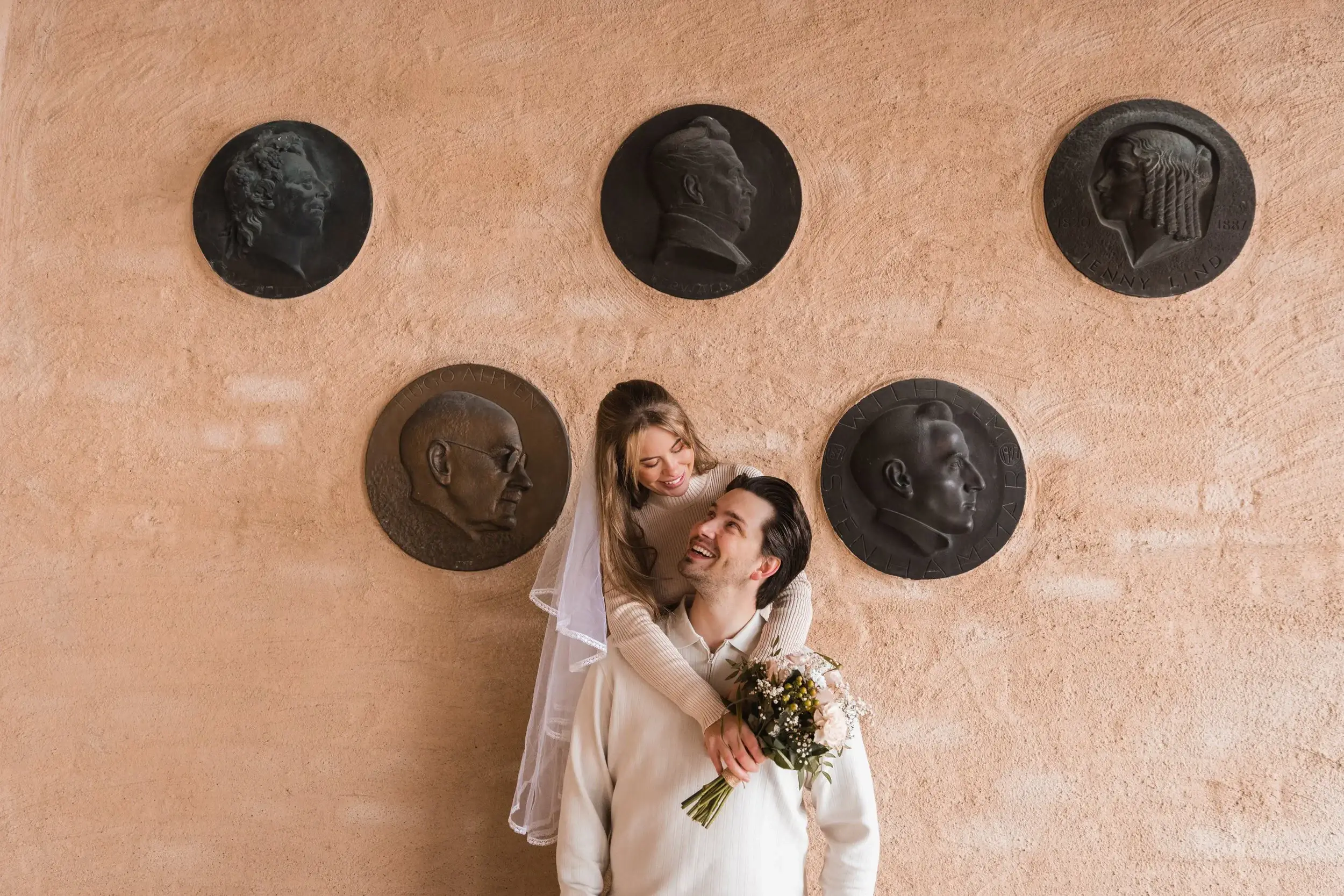 Newlyweds holding hands and showing their wedding rings.