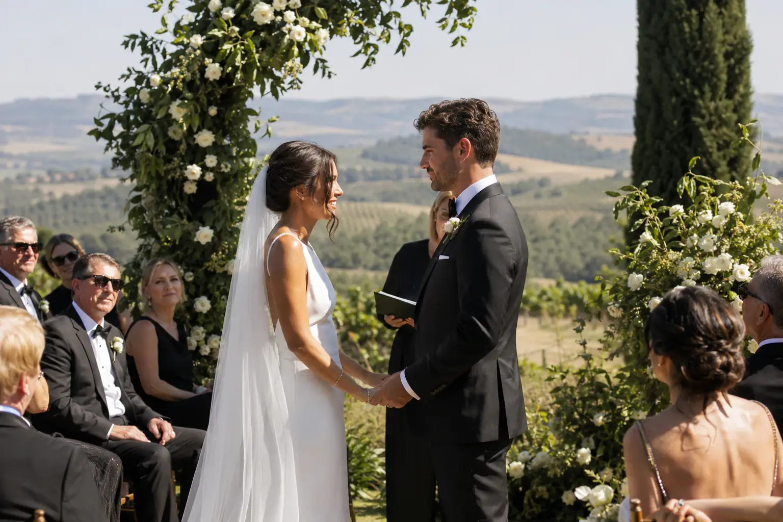 A couple photographed with lake and mountain scenery behind them.