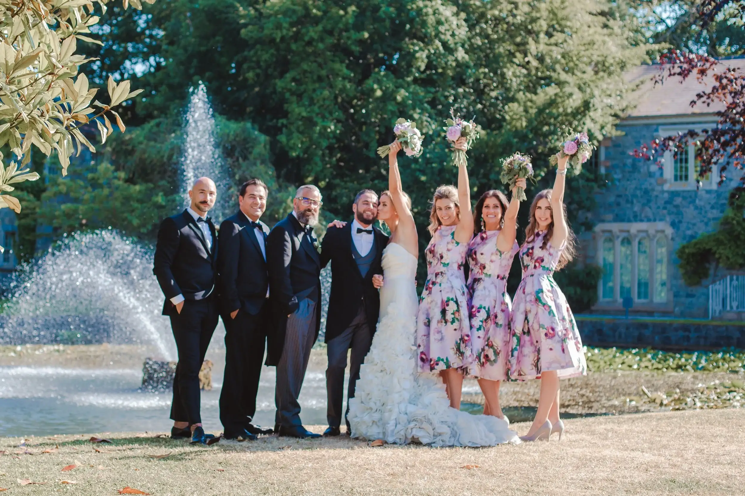 A bride celebrating with her wedding party in a garden.