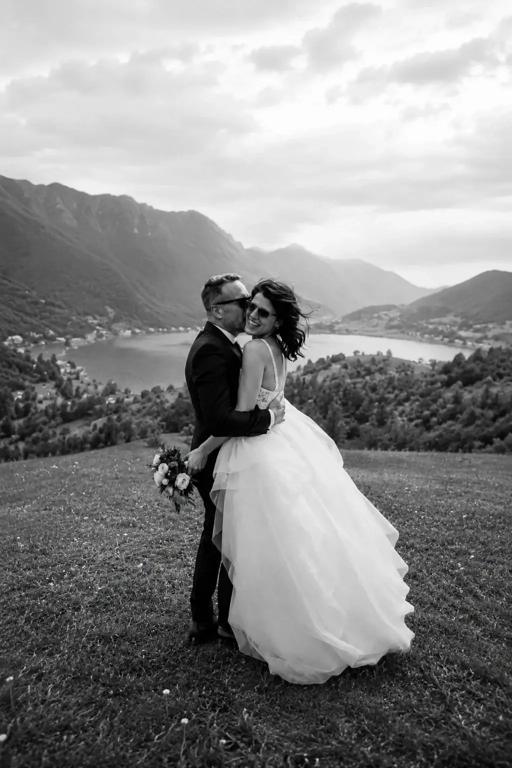 Black-and-white portrait of newlyweds in a mountain landscape.
