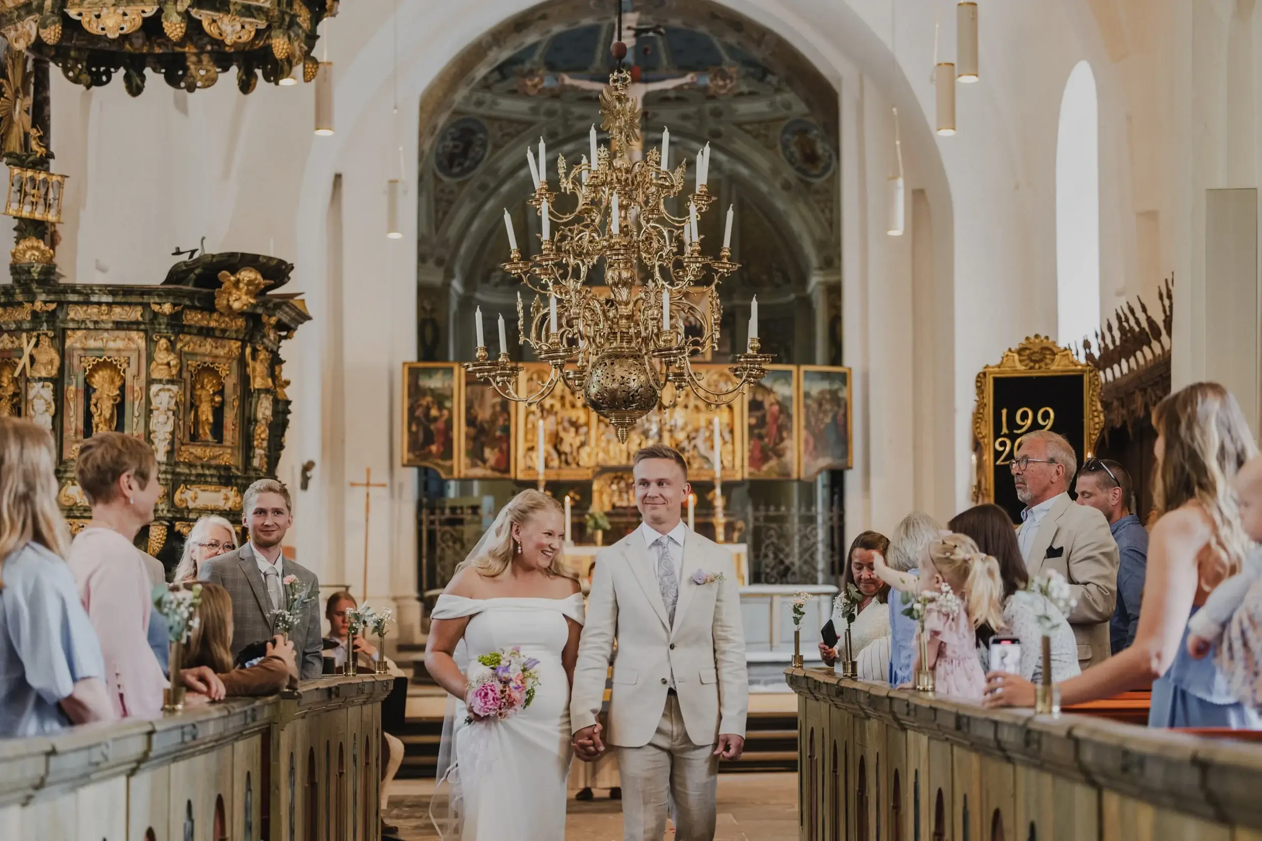 A couple holding hands during their wedding ceremony.