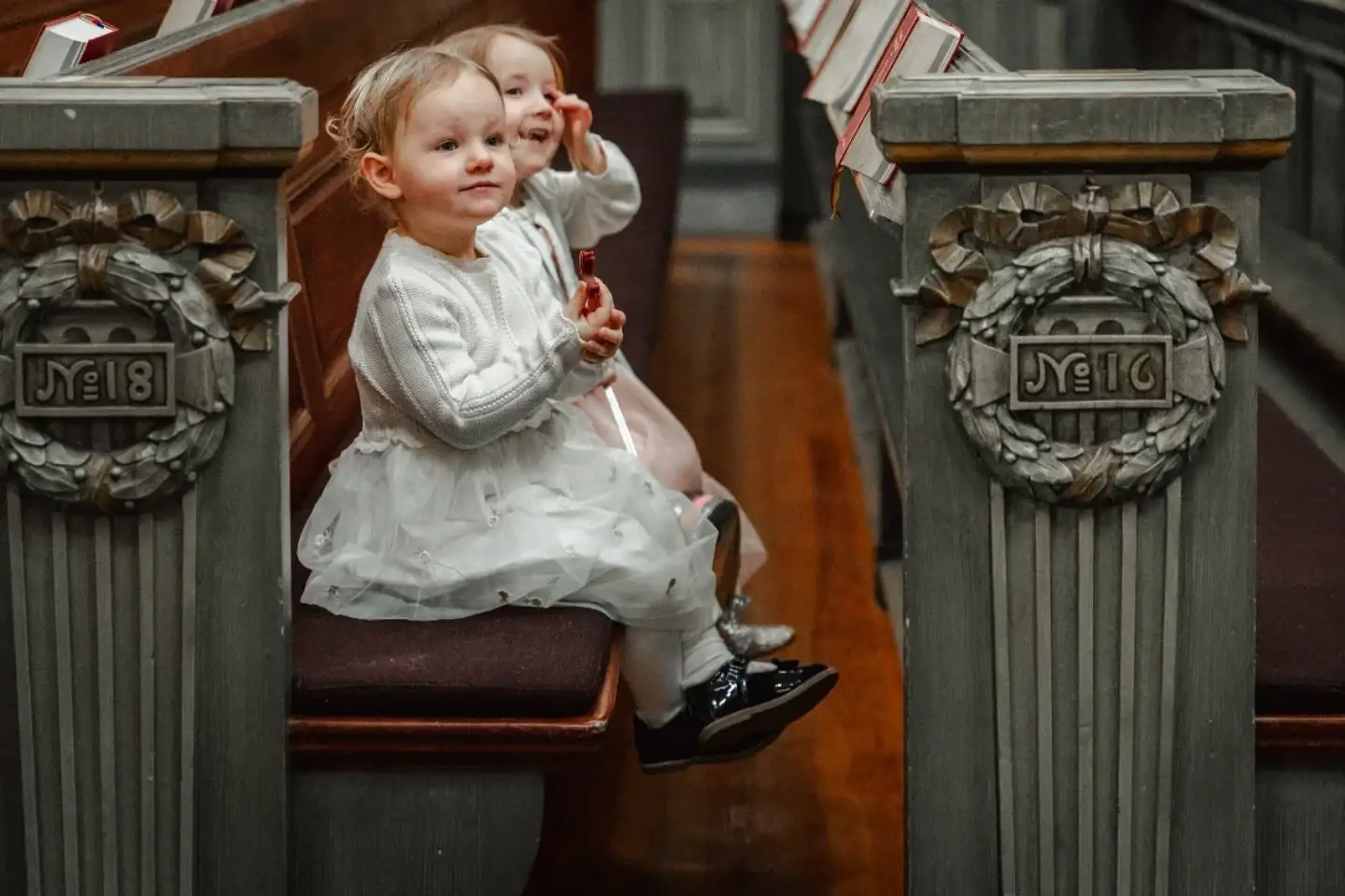 Two young children seated in a church pew.