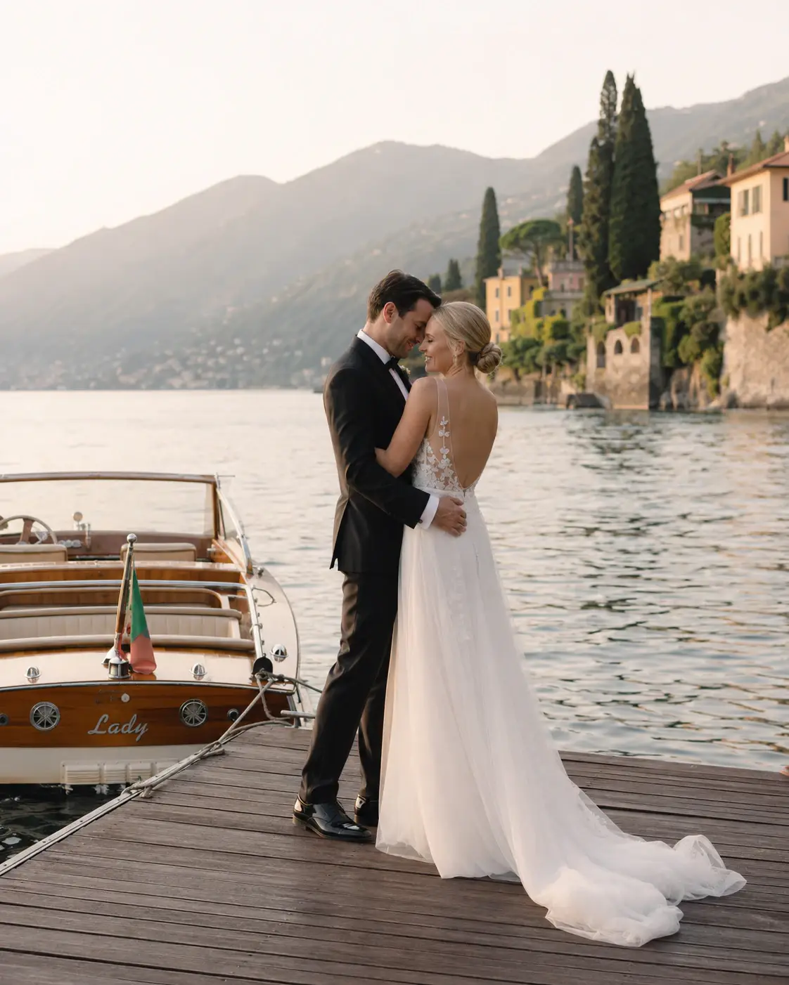 Newlyweds embracing beside a lake.
