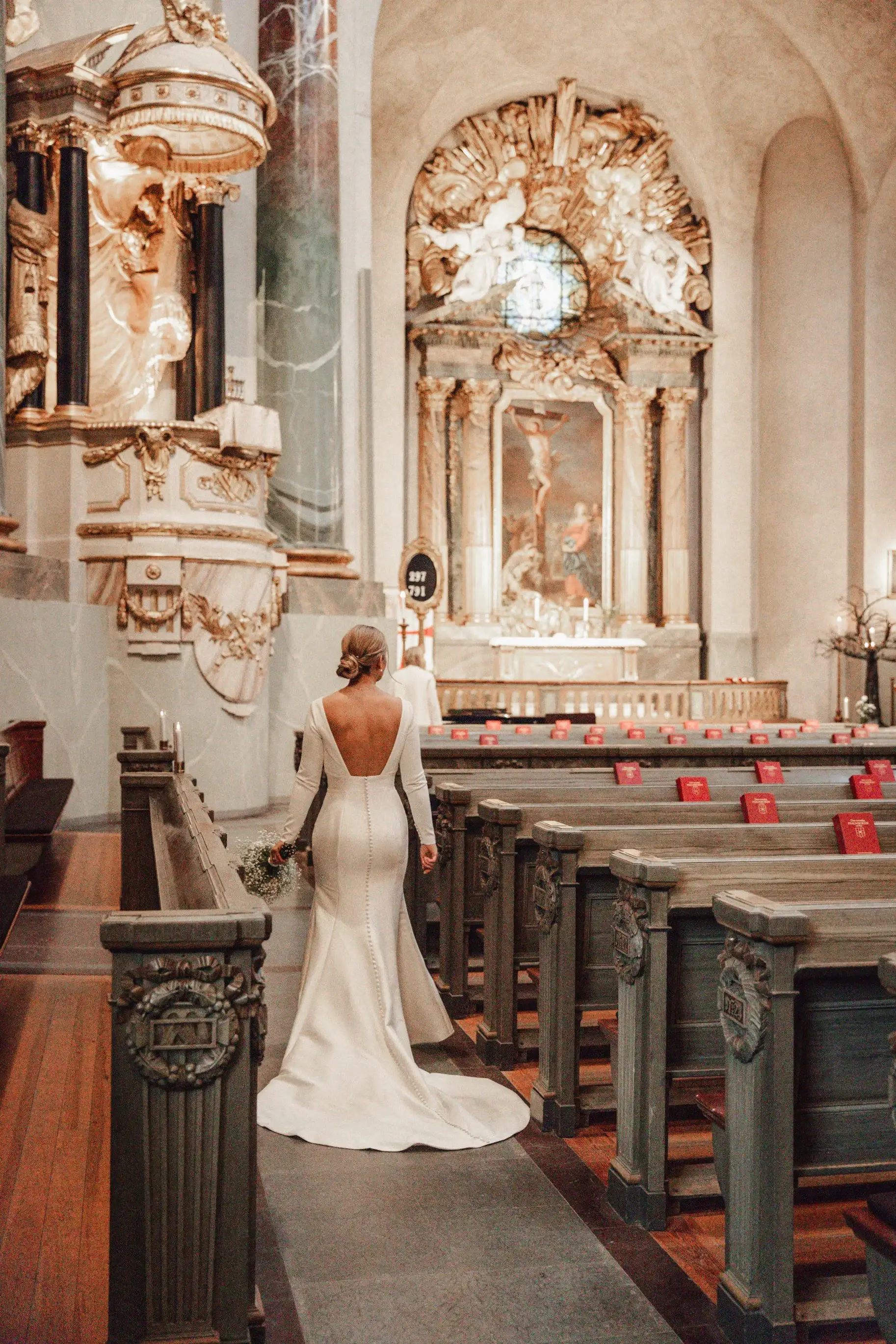 Bride walking down the aisle inside an ornate church.