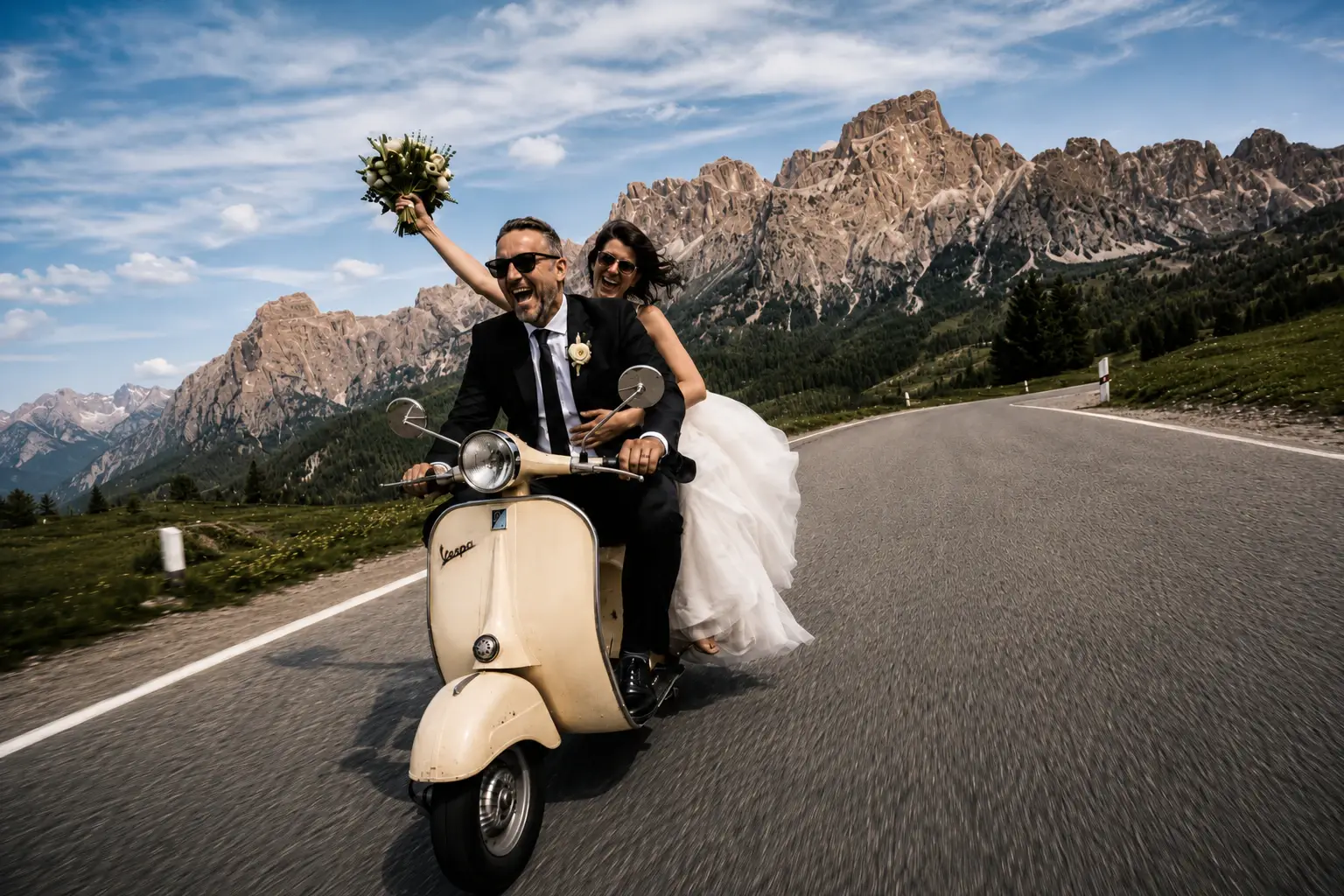 A couple riding a vintage Vespa through an Italian village street.
