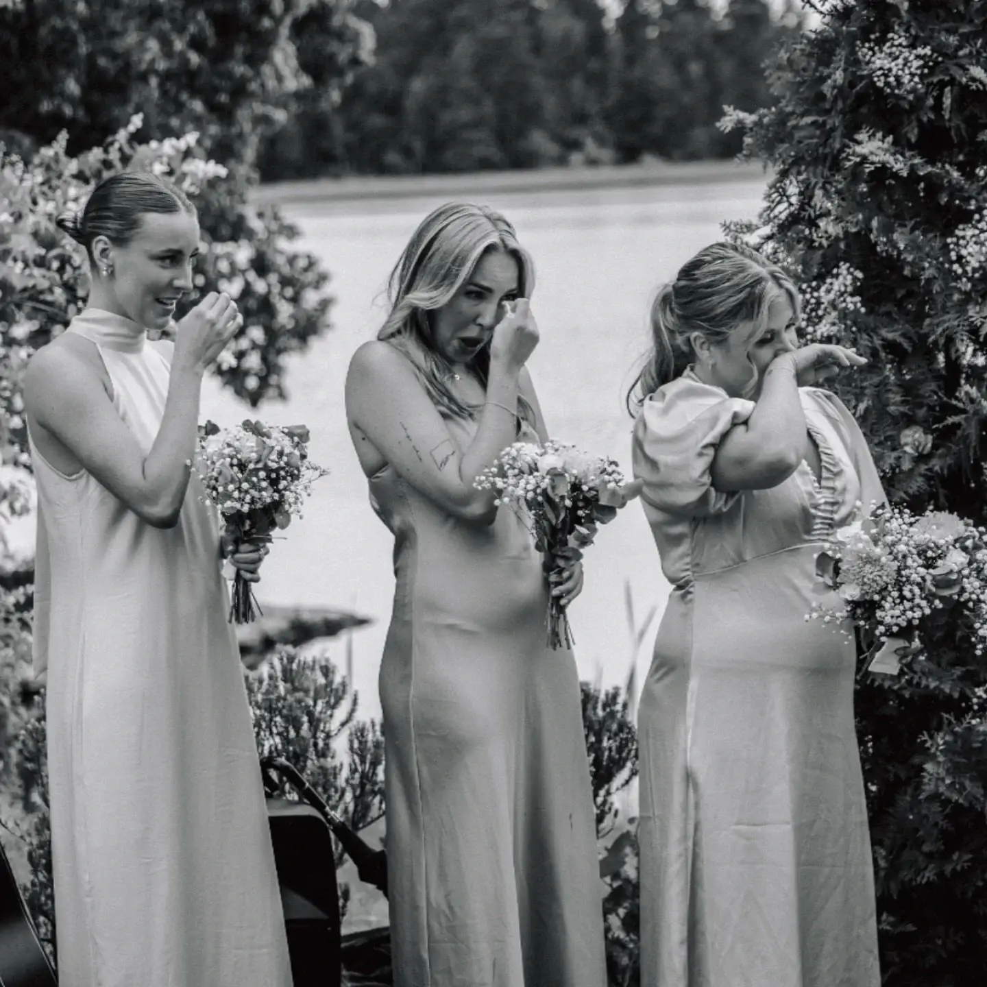 Three bridesmaids sharing an emotional moment.