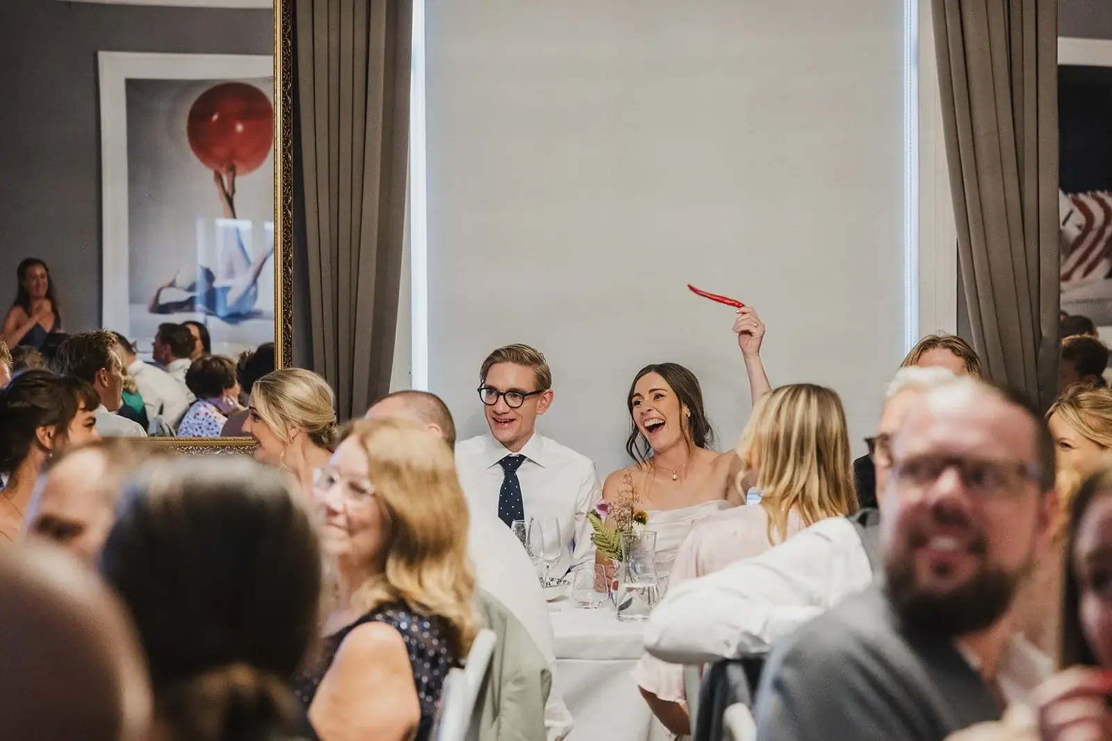 Wedding guests laughing together during the reception.
