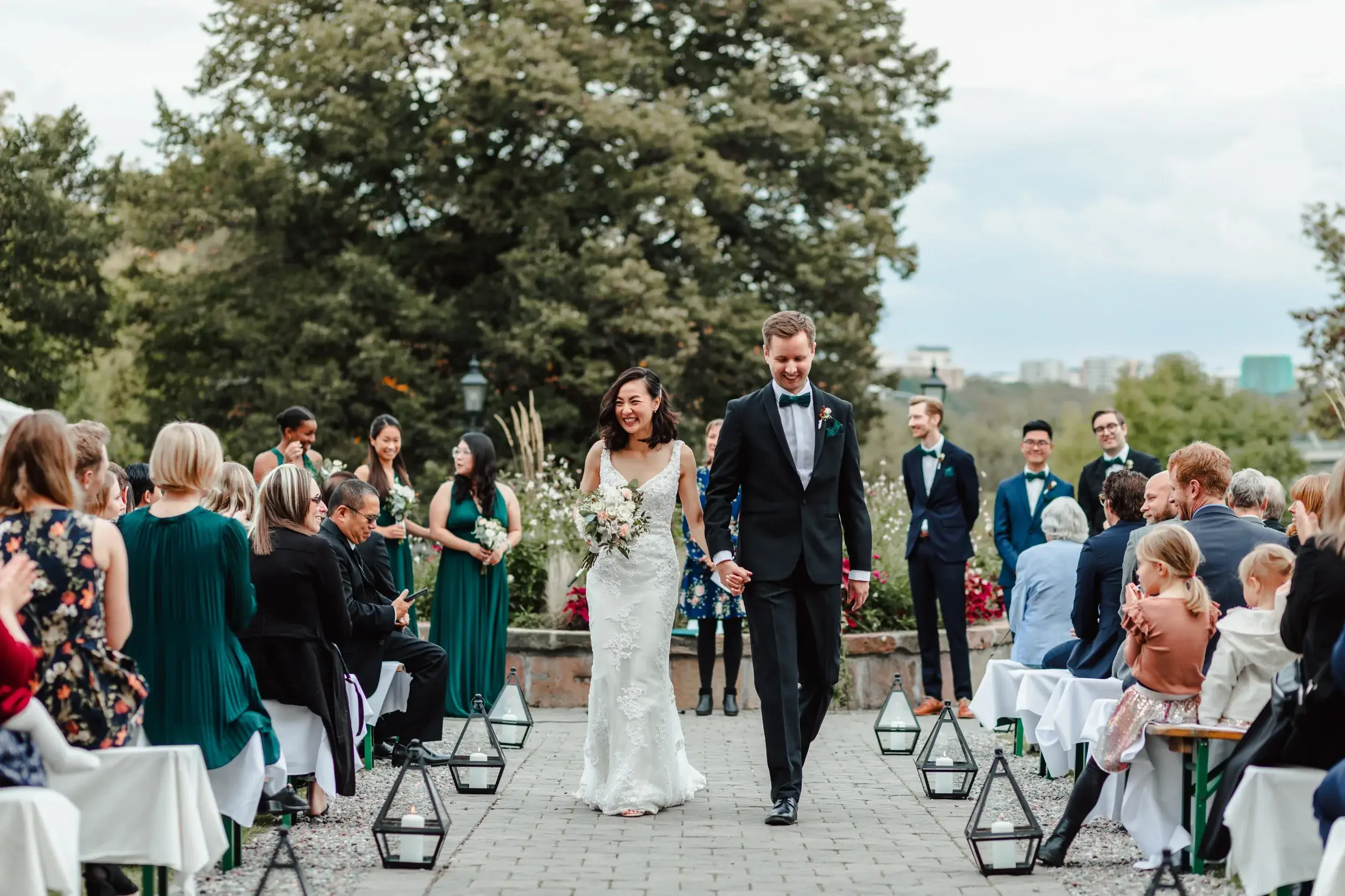 Bride walking down the aisle during an outdoor garden ceremony.